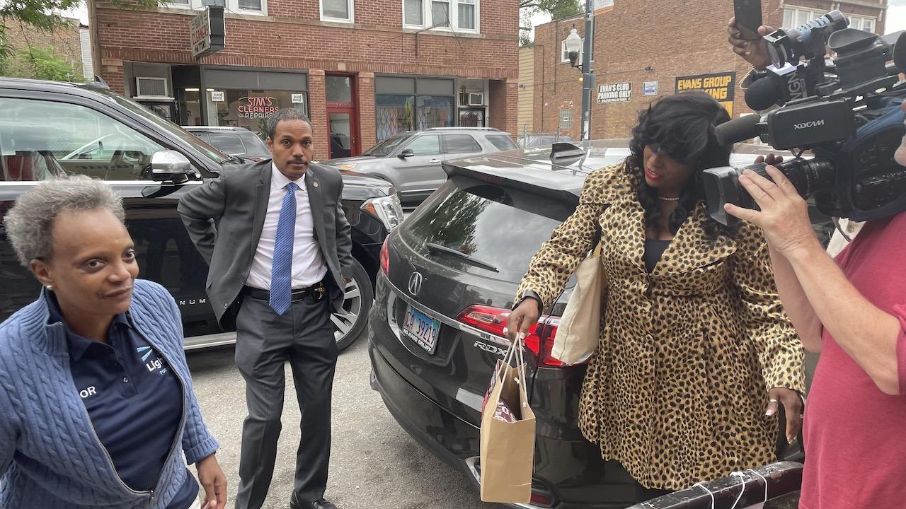Mayor Lori Lightfoot hits the campaign trail on June 7, 2022, as her security detail looks on. (Heather Cherone/WTTW News)