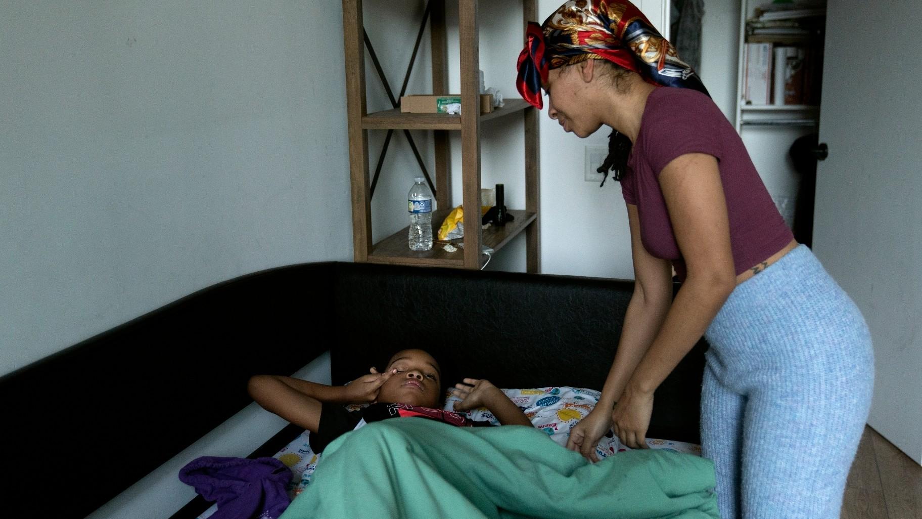 Johnae Strong wakes her 10-year-old son Akeim Smith as they ready for school and work Friday, Feb. 10, 2023, in Chicago. (AP Photo / Erin Hooley)