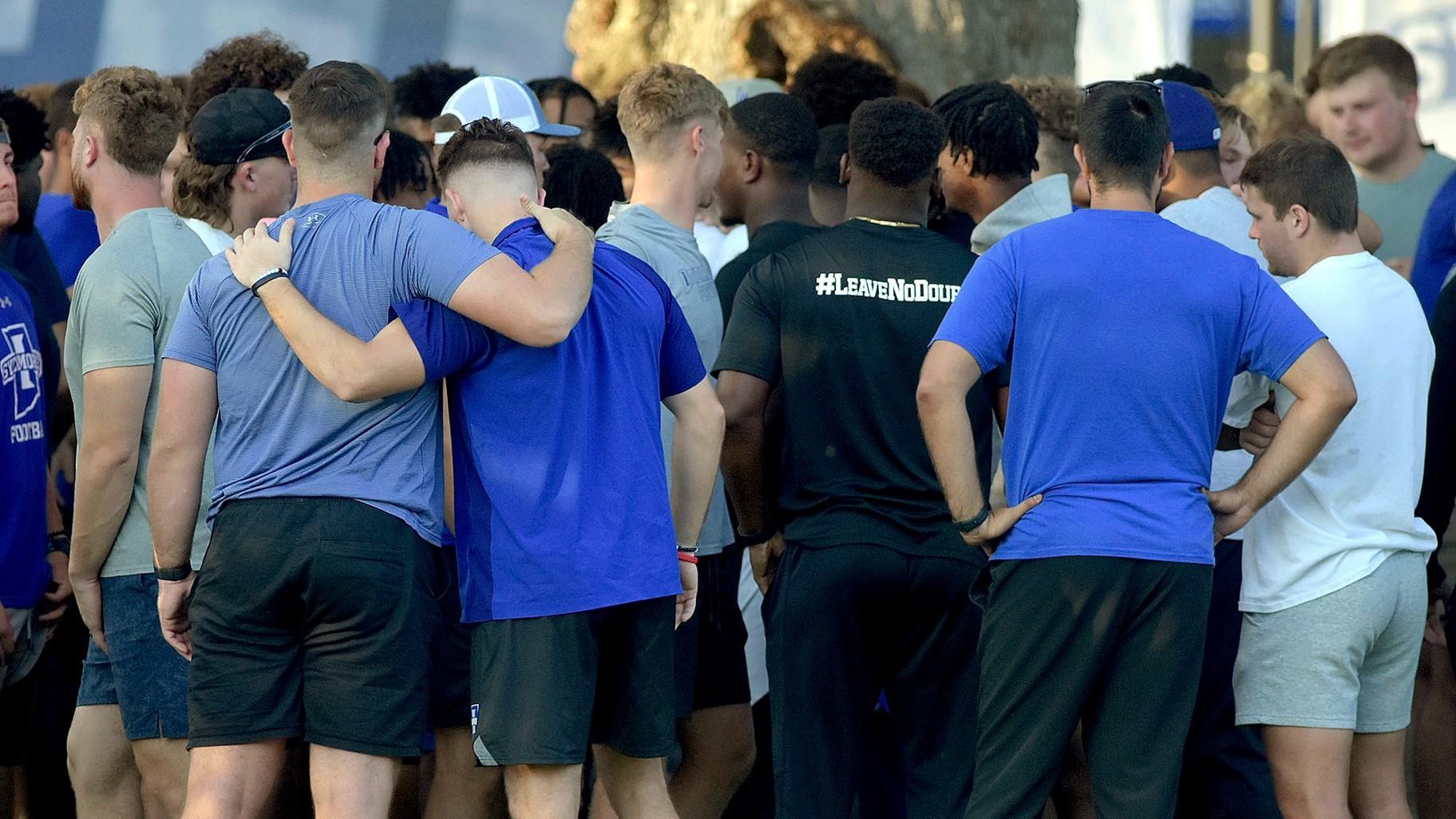 Members of the Indiana State football team console one another after a vigil at Memorial Stadium in Terre Haute, Ind., on Sunday, Aug. 21, 2022, for students, including fellow football players, who were involved in a car crash earlier in the day. (Joseph C. Garza / The Tribune-Star via AP)