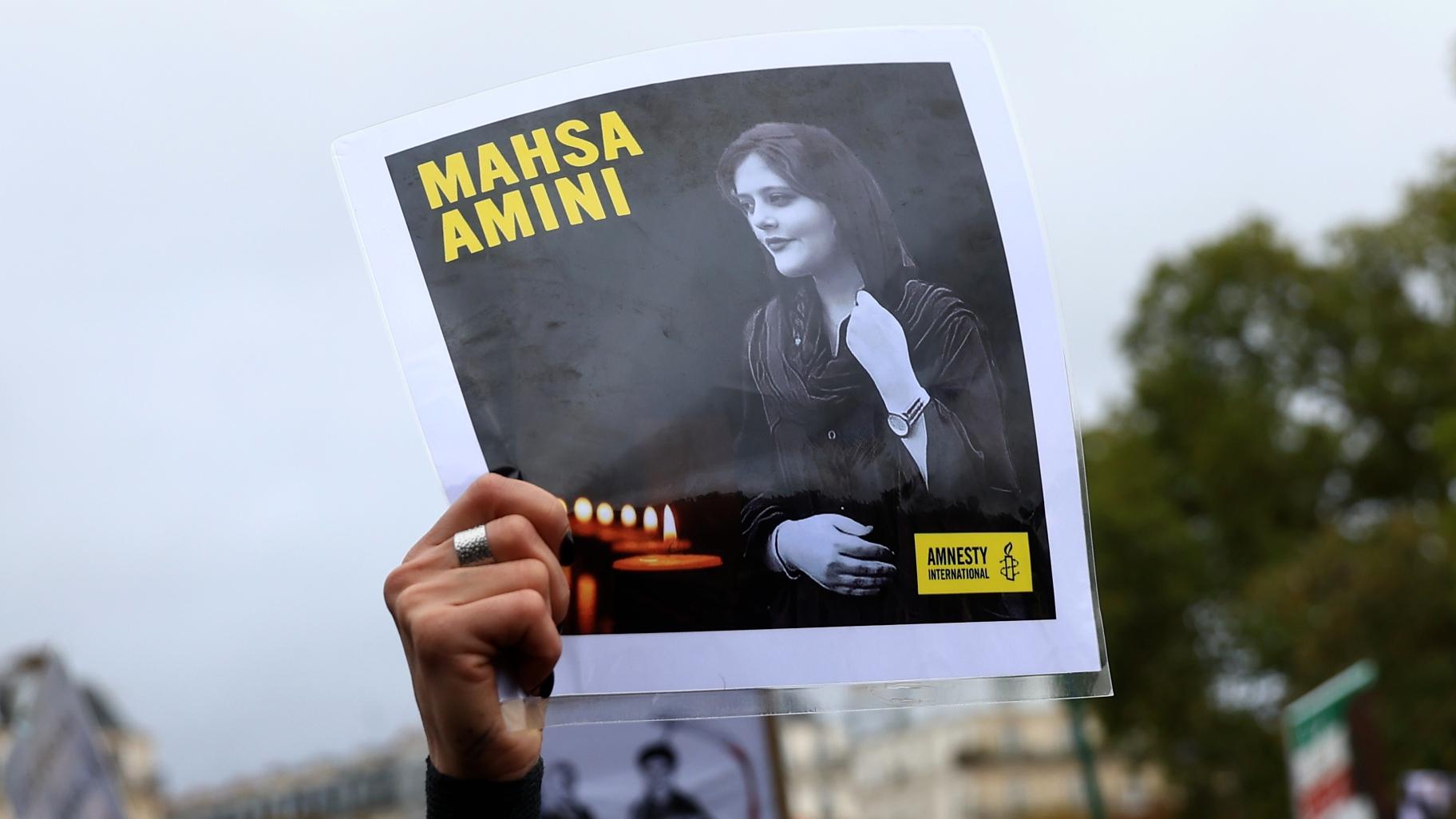 A protester shows a portrait of Mahsa Amini during a demonstration to support Iranian protesters standing up to their leadership over the death of a young woman in police custody, Sunday, Oct. 2, 2022 in Paris. (AP Photo / Aurelien Morissard)