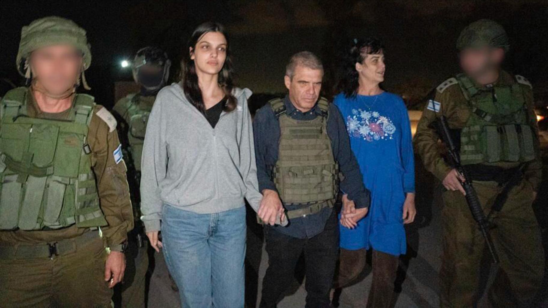 In this photo provided by the Government of Israel, Judith Raanan, right, and her 17-year-old daughter Natalie are escorted by Israeli soldiers and Gal Hirsch, Prime Minister Benjamin Netanyahu's special coordinator for returning the hostages, as they return to Israel from captivity in the Gaza Strip, Friday, Oct. 20, 2023. (Government of Israel via AP Photo)