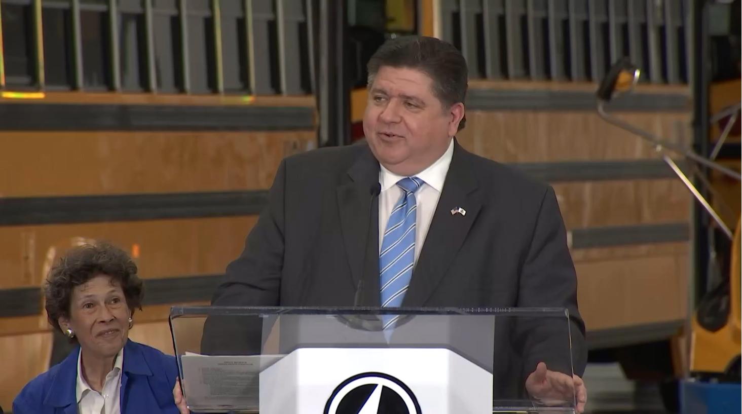 : Gov. JB Pritzker speaks at the grand opening of a new Lion Electric assembly plant in Will County. The Canada-based company specializes in medium- and heavy-duty electric vehicles, including electric school buses. (Credit: Illinois.gov)