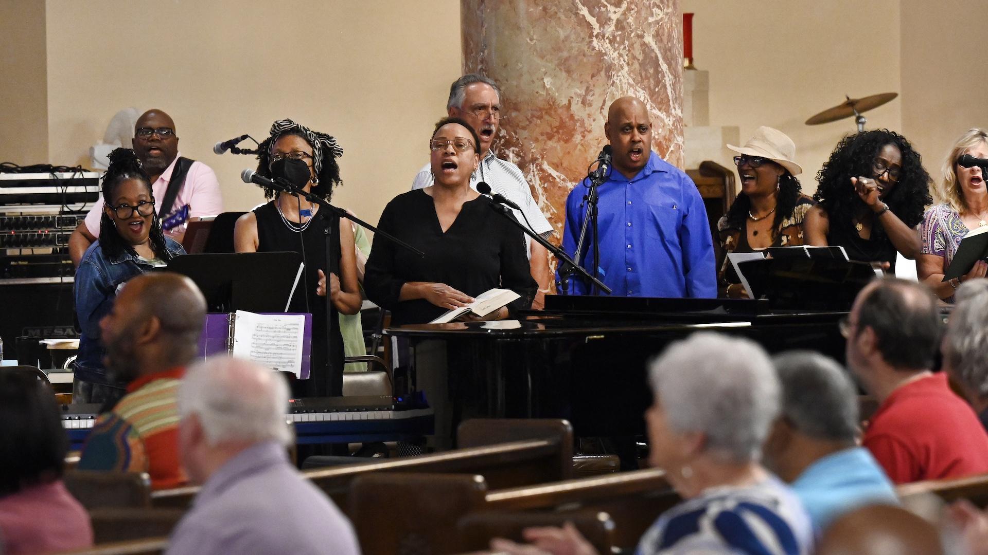 The Gesu Choir, standing, is cheered on by the congregation as they sing during Mass, Sunday, June 18, 2023, at Gesu Catholic Church in Detroit. (AP Photo/Jose Juarez)