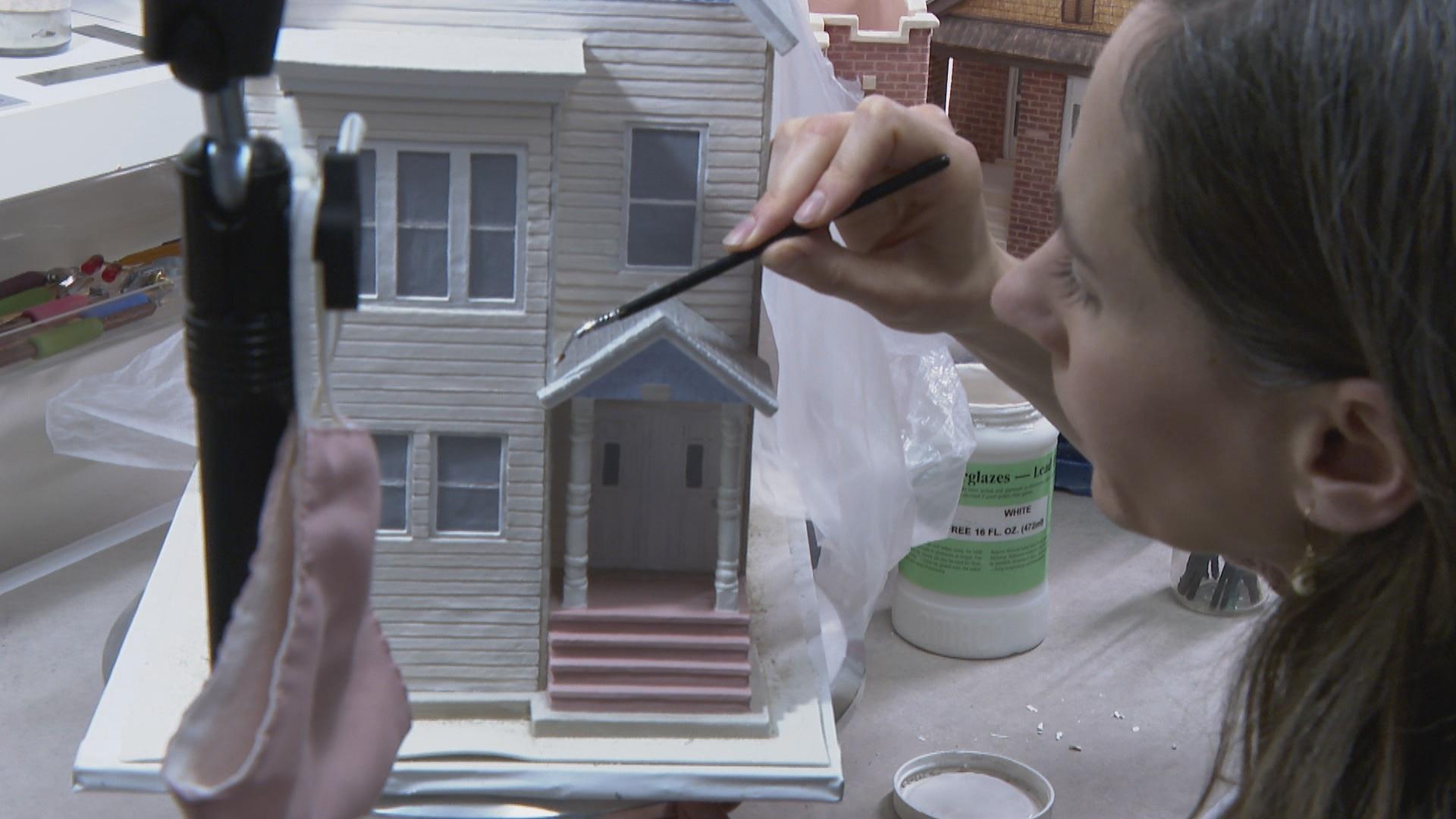 Katie Lofenberger paints a ceramic house inspired by Chicago architecture.  (WTTW News)
