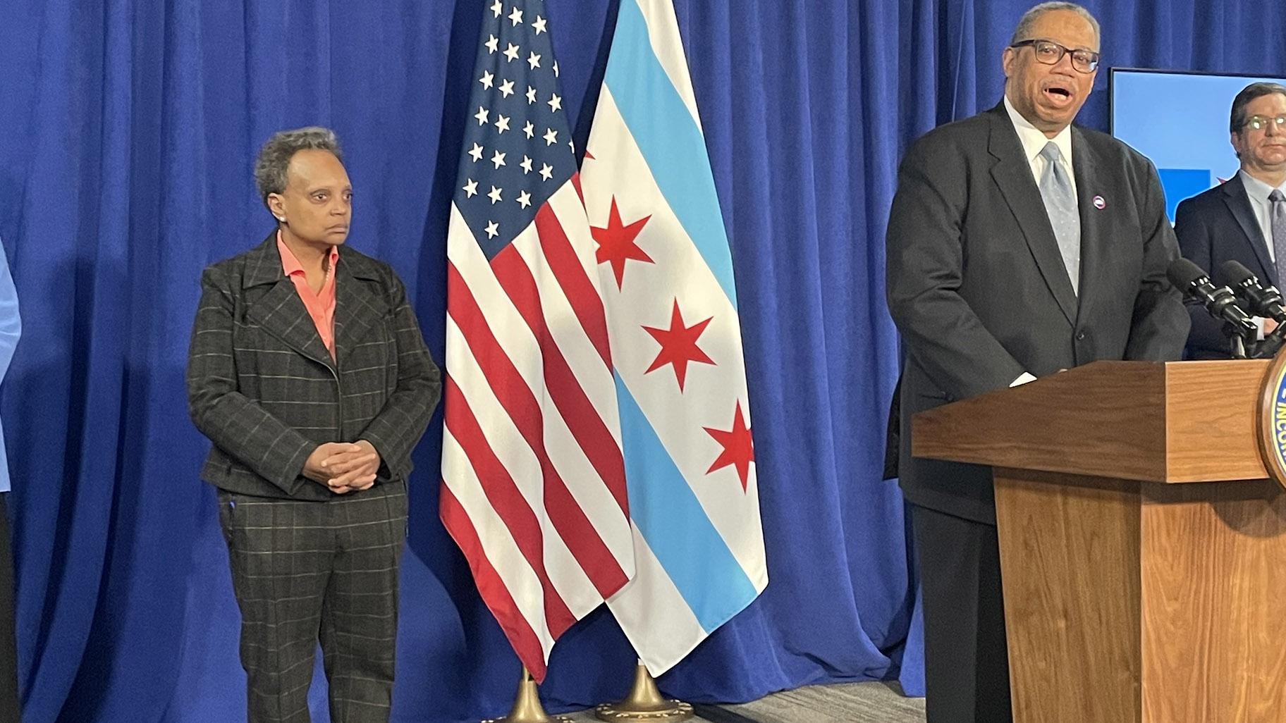 Mayor Lori Lightfoot looks on as CTA President Dorval Carver addresses the news media. (Heather Cherone / WTTW News)