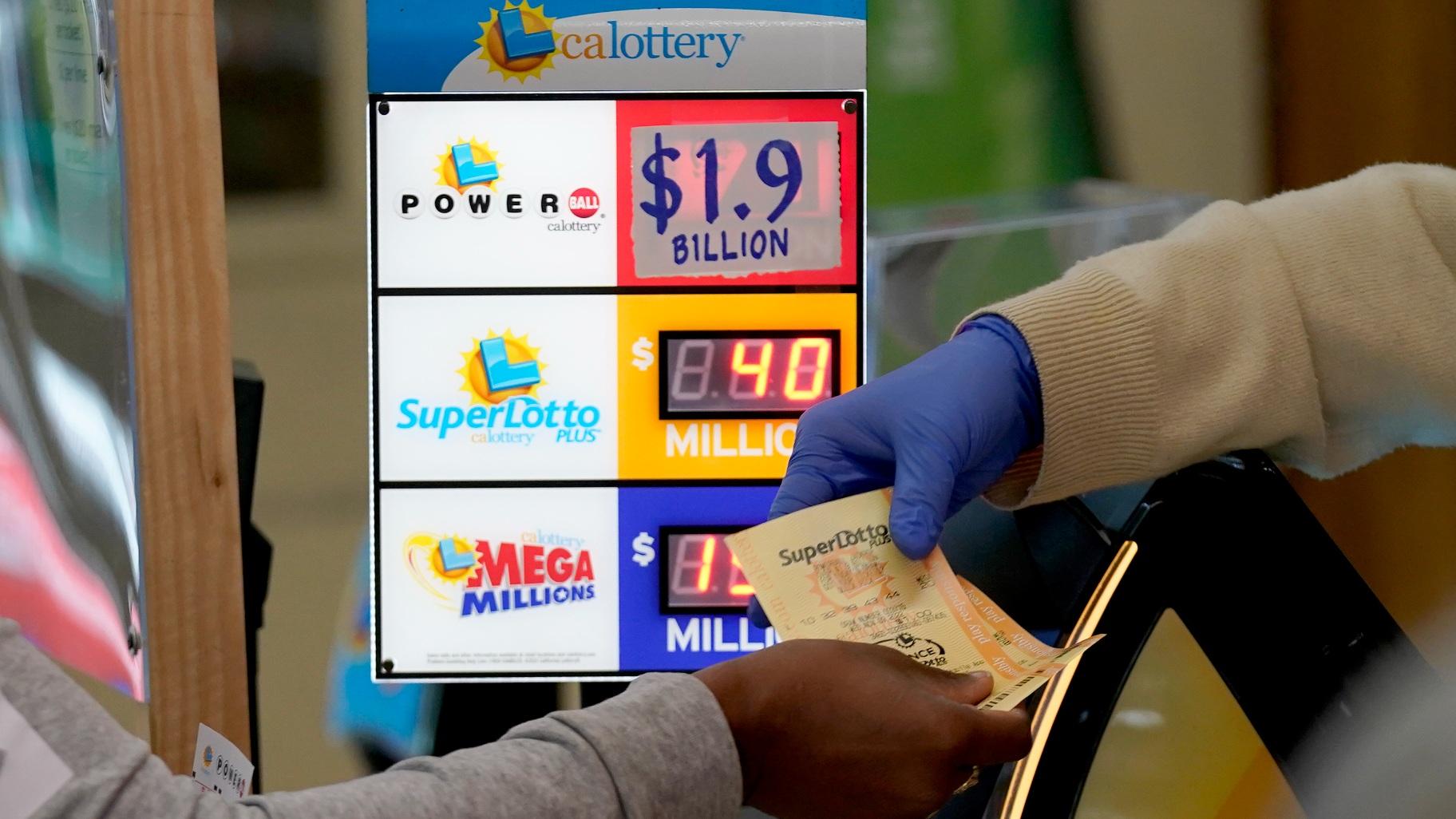 A customer is handed Powerball tickets purchased at Lichine's Liquor & Deli in Sacramento, Calif., Monday, Nov. 7, 2022. Monday night's drawing is estimated to be a record .9 billion. (AP Photo / Rich Pedroncelli)