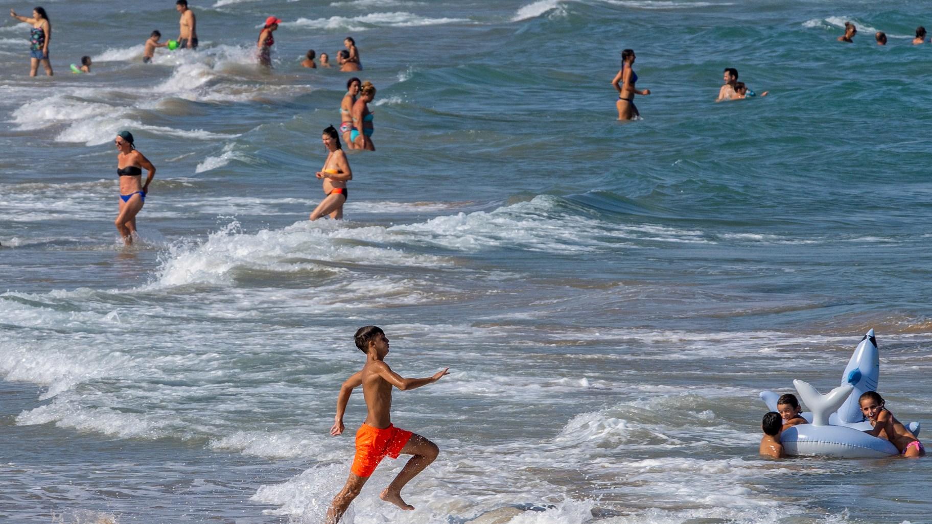 People cool off on Puerto de Sagunto beach, east Spain on Tuesday, Aug. 16, 2022. (AP Photo / Alberto Saiz)