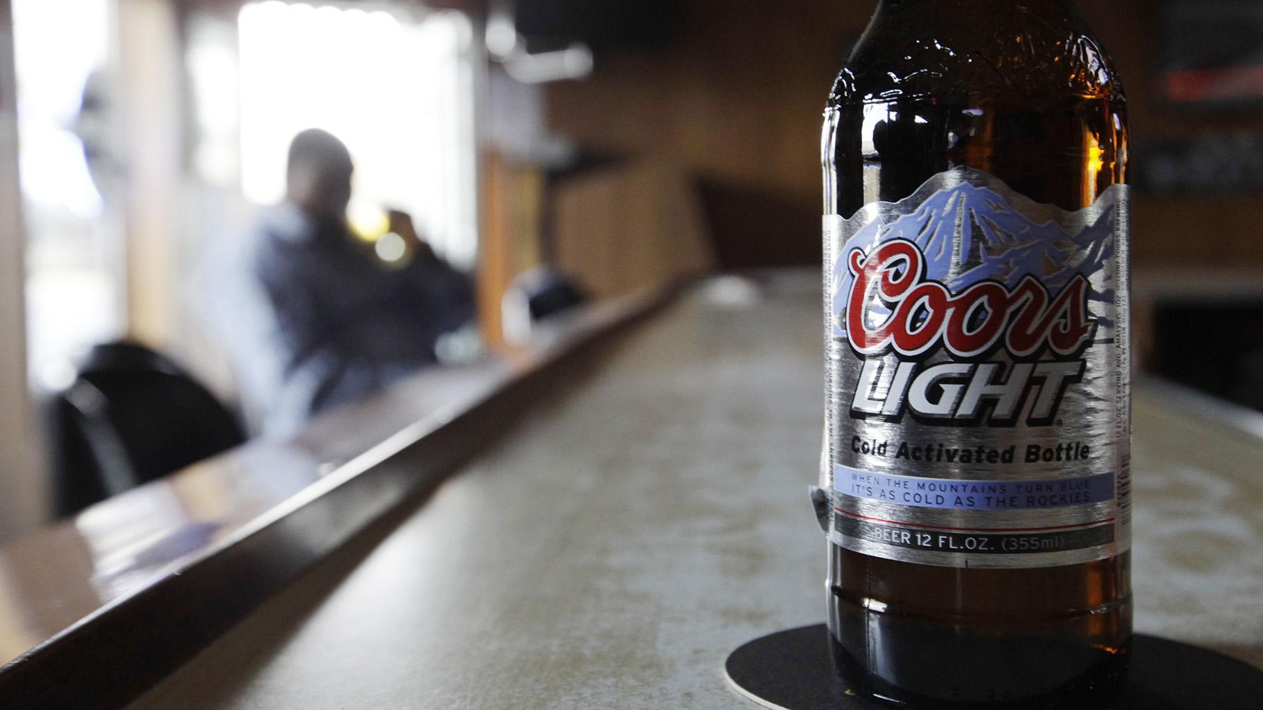 In this Monday, May 4, 2009, file photo, a bottle of Coors Light sits on the bar as a patron sips a beer at a tavern in Blue Island, Ill. (AP Photo / M. Spencer Green, File)