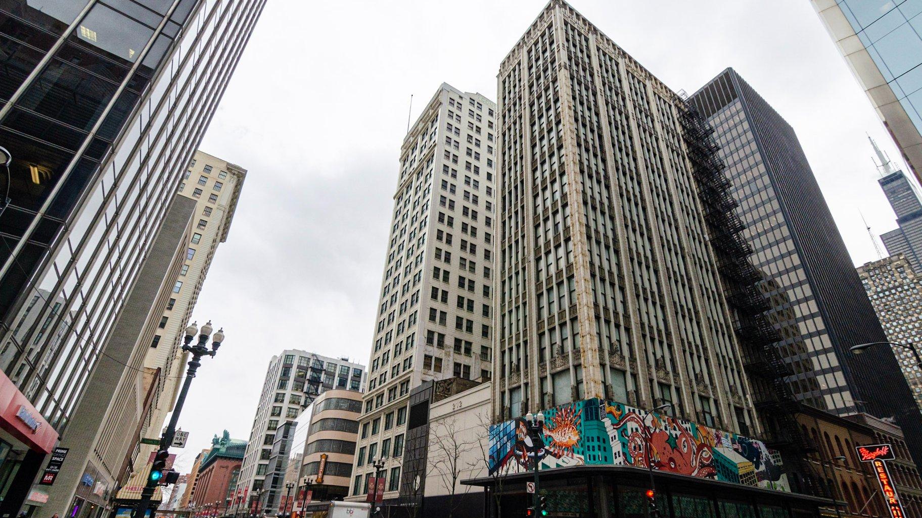 The federal government plans to tear down the building at 208-212 S. State St., the shorter of the two properties between the threatened Century Building and Consumers Building skyscrapers, pictured last year before a sidewalk closure. (Preservation Chicago / Eric Allix Rogers)