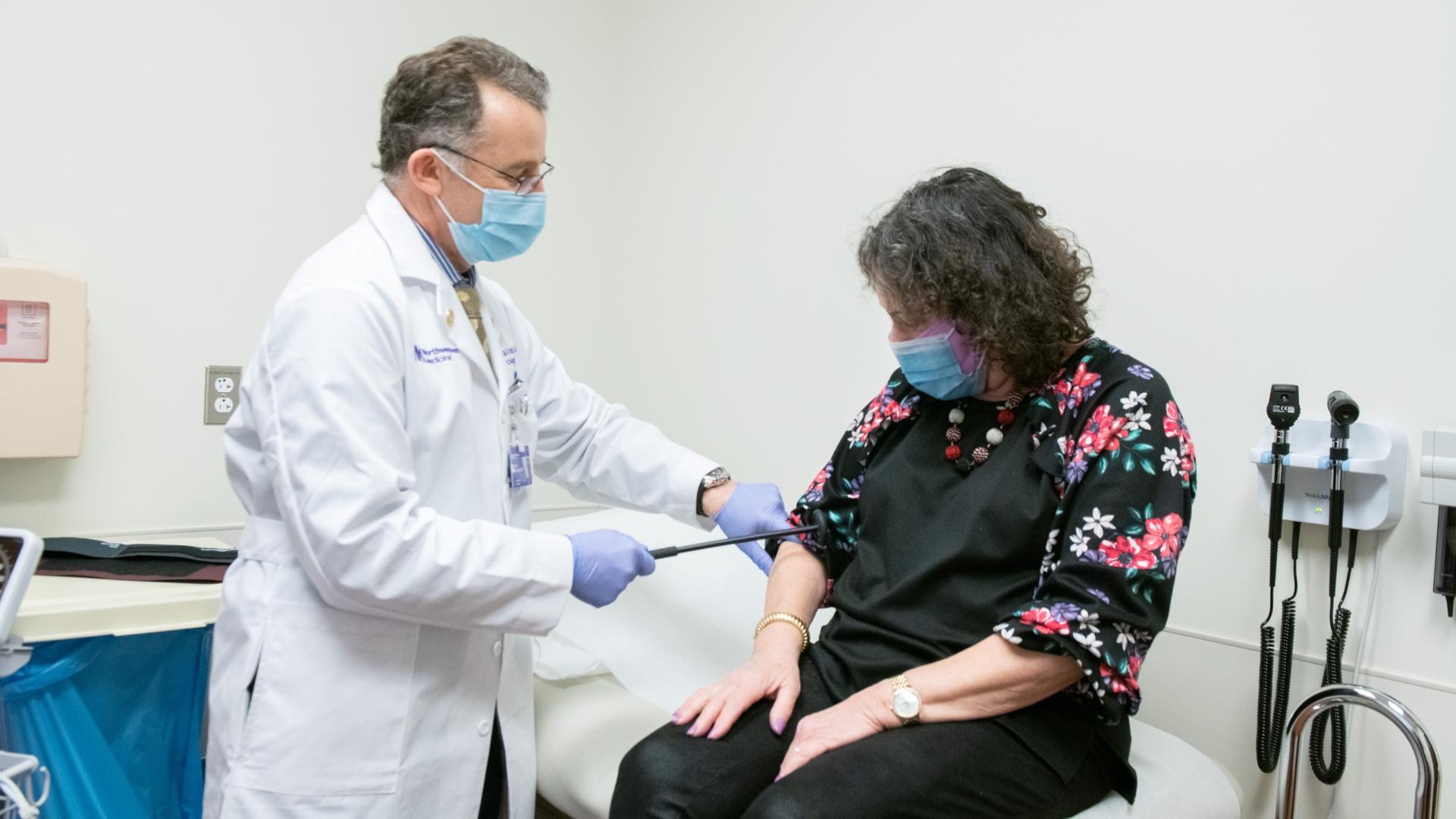 Dr. Igor Koralnik, left, examines a patient. (Credit: Northwestern Medicine)