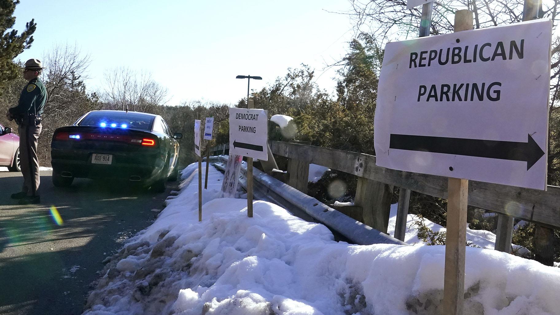 In this Feb. 24, 2021, file photo, a sign directs Republican and Democrat legislators to their parking areas as a N.H. State Trooper watches the flow of traffic prior to a New Hampshire House of Representatives session held at NH Sportsplex, due to the coronavirus in Bedford, N.H. (AP Photo / Charles Krupa, File)