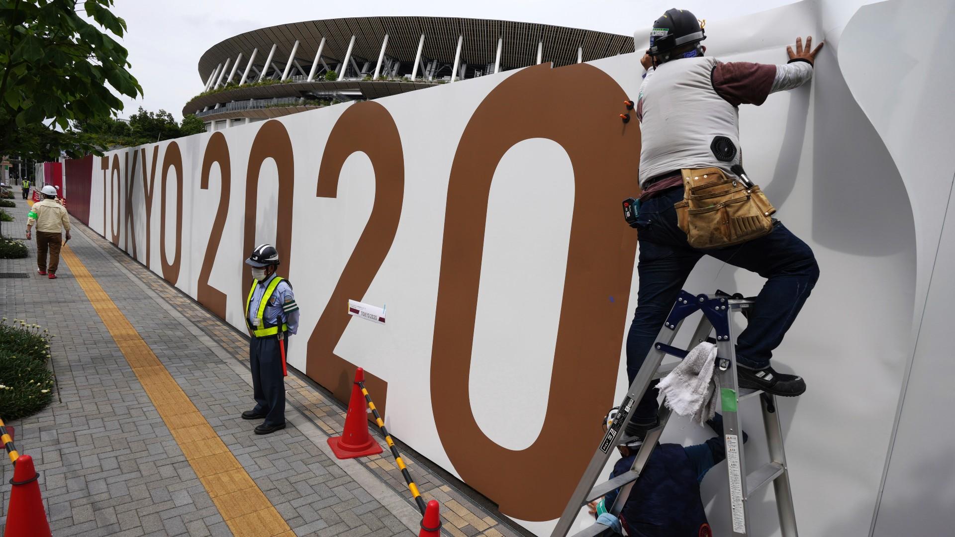 Workers paste the overlay on the wall of the National Stadium, where opening ceremony and many other events are scheduled for the postponed Tokyo 2020 Olympics, Wednesday, June 2, 2021, in Tokyo. (AP Photo / Eugene Hoshiko)