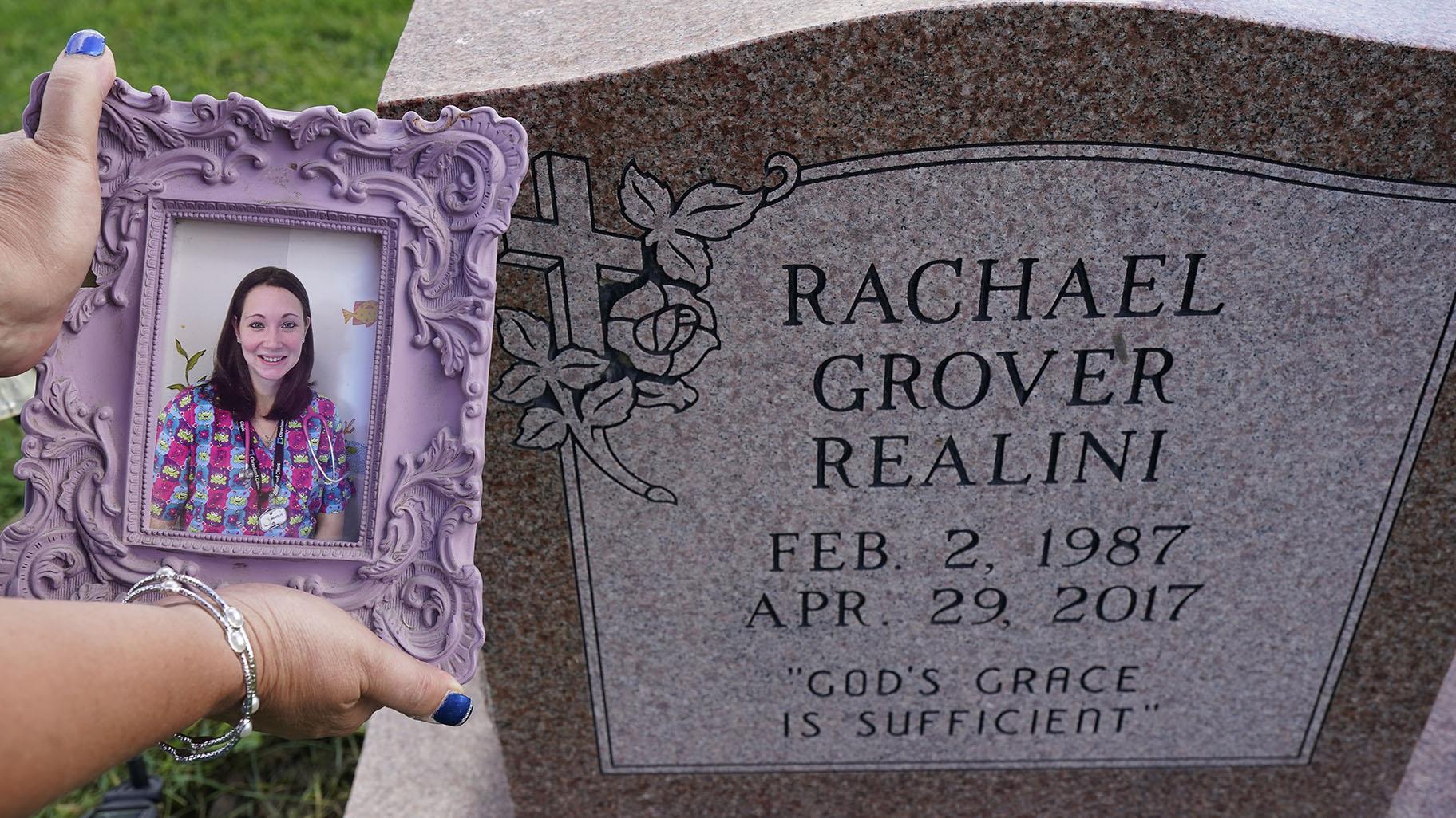 Sharon Grover holds up a photograph of her daughter, Rachael, over the gravesite at Fairview Cemetery, Tuesday, Sept. 28, 2021, in Mesopotamia, Ohio. Grover believes her daughter started using prescription painkillers around 2013 but missed any signs of her addiction as her daughter, the oldest of five children, remained distanced. (AP Photo / Tony Dejak)
