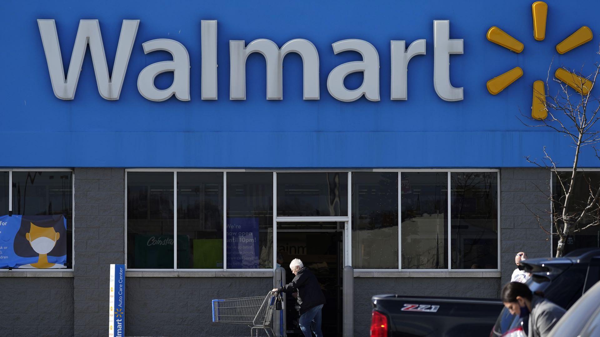 In this Nov. 5, 2020 file photo, a woman pushes a shopping cart to enter a Walmart in Rolling Meadows, Ill. Walmart on Tuesday, Nov. 15, 2022 become the latest major player in the drug industry to announce a plan to settle lawsuits filed by state and local governments over the toll of powerful prescription opioids sold at its pharmacies with state and local governments across the U.S. (AP Photo/Nam Y. Huh, File)