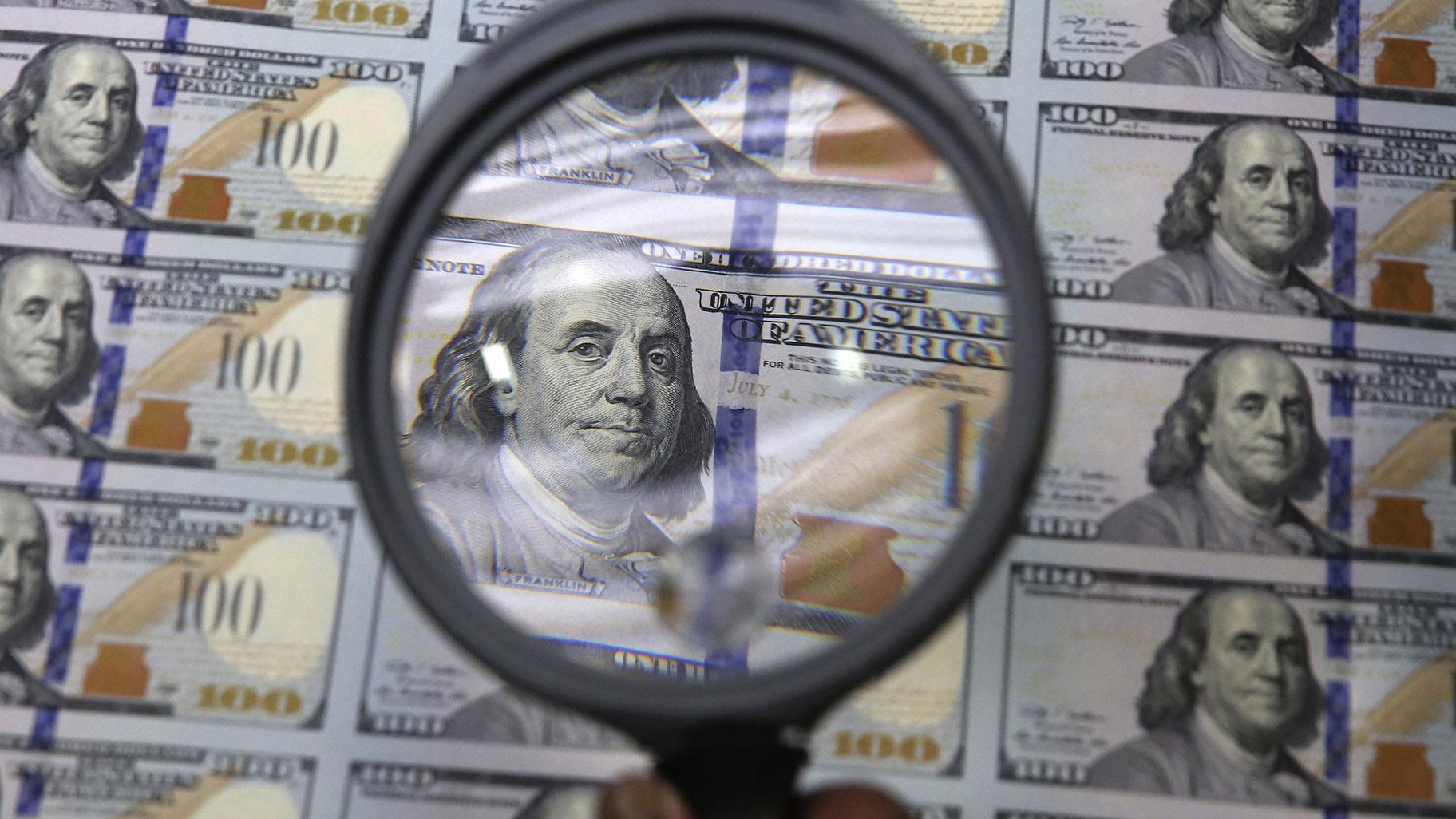 A sheet of uncut 00 bills is inspected during the printing process at the Bureau of Engraving and Printing Western Currency Facility in Fort Worth, Texas, on Sept. 24, 2013. (AP Photo / LM Otero, File)