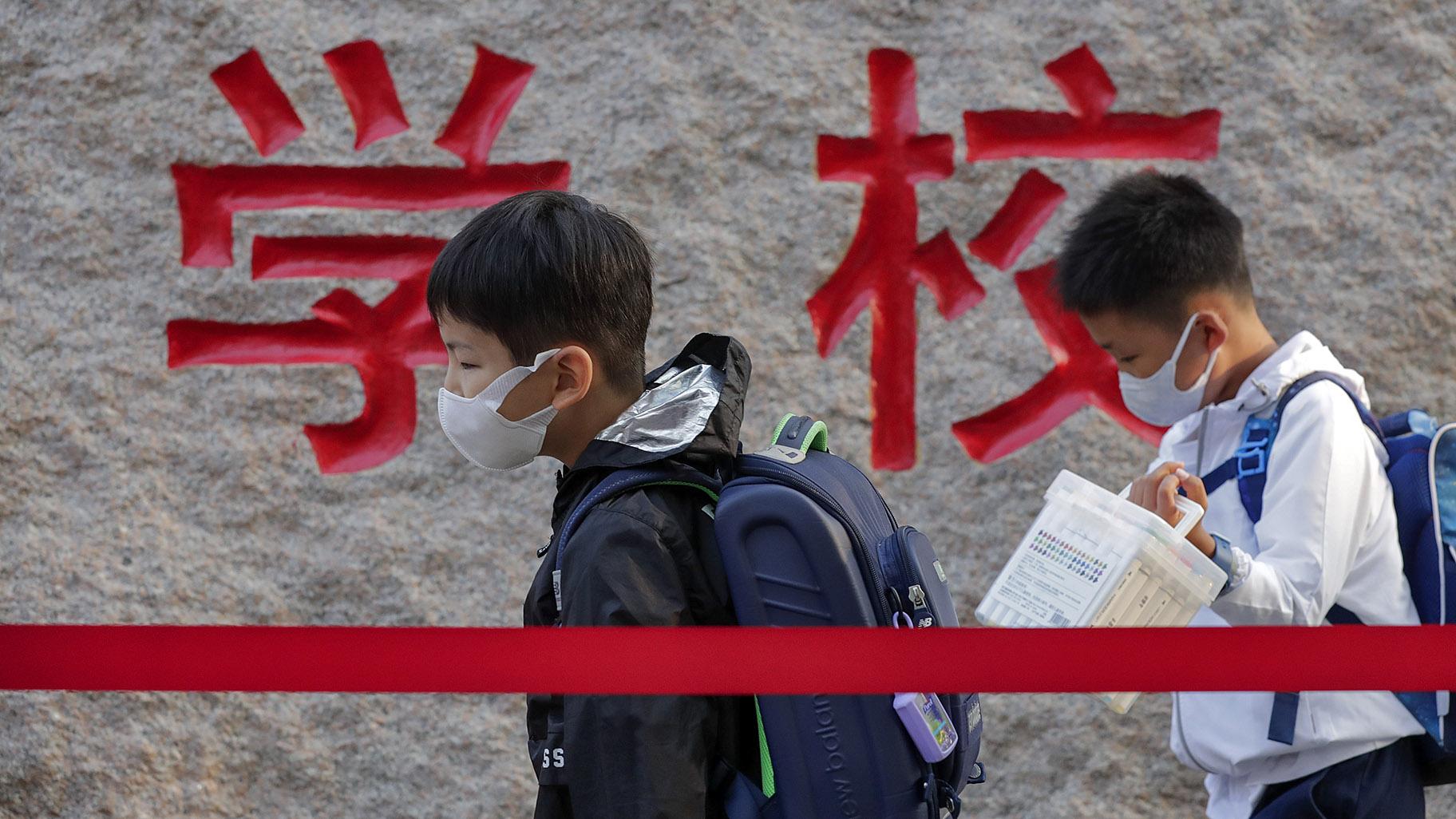 In this Sept. 7, 2020 file photo, students wearing face masks to help curb the spread of the coronavirus walk in line as they arrive at a primary school in Beijing. (AP Photo / Andy Wong, File)