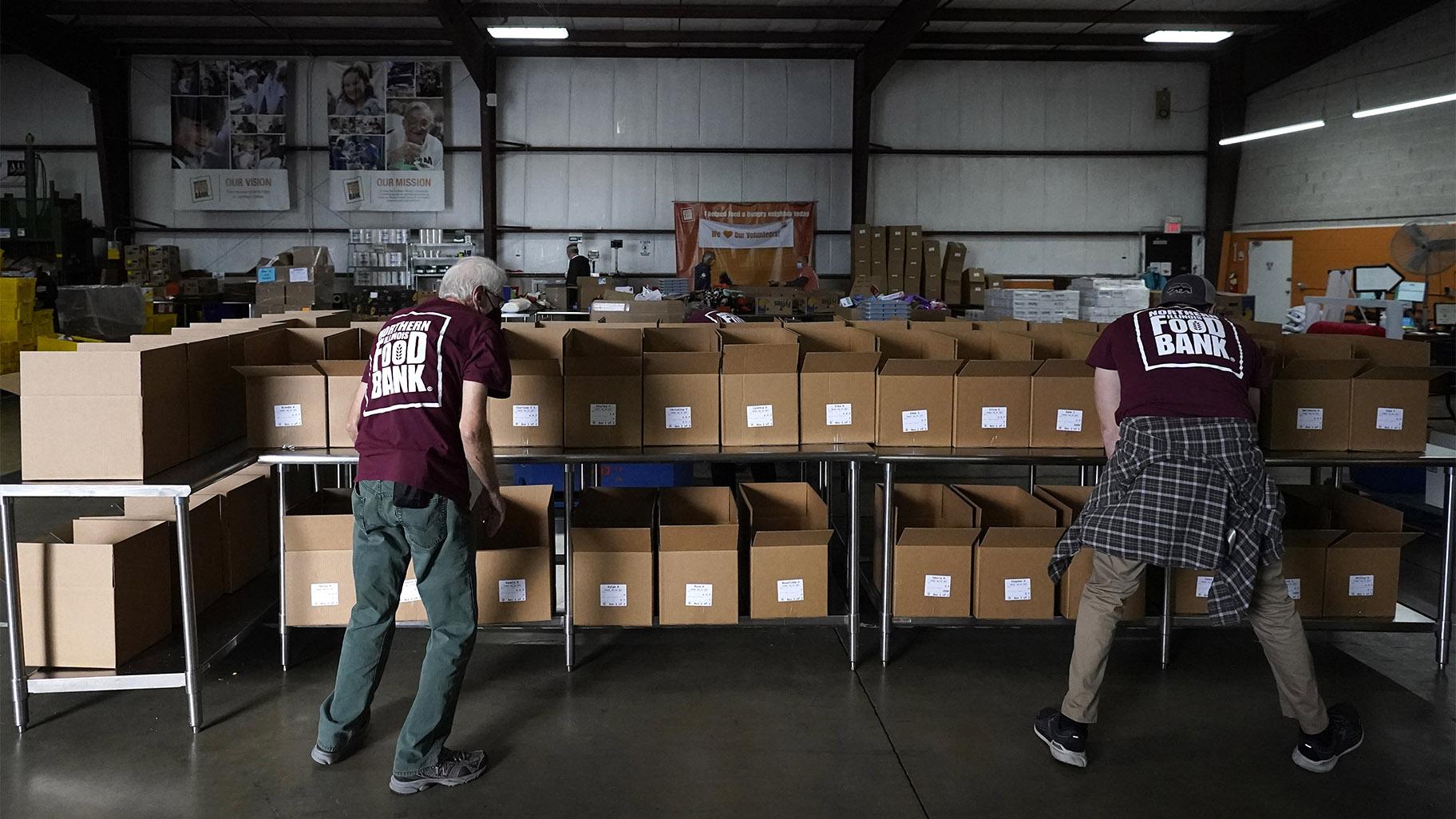 Volunteers Joe O'Connor, left, and Eric Leuck prepare boxes that will be filled with food at the Northern Illinois Food Bank and delivered by DoorDash drivers for area residents who are homebound Wednesday, Nov. 10, 2021, in Park City, Ill. (AP Photo / Charles Rex Arbogast)