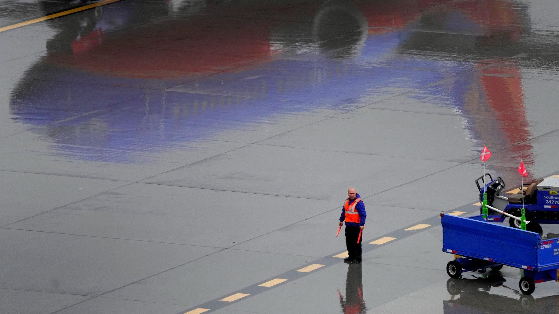 A Southwest Airlines ground operations crew member waits to guide an arriving jet into a gate, Wednesday, Dec. 28, 2022, at Sky Harbor International Airport in Phoenix. (AP Photo / Matt York)