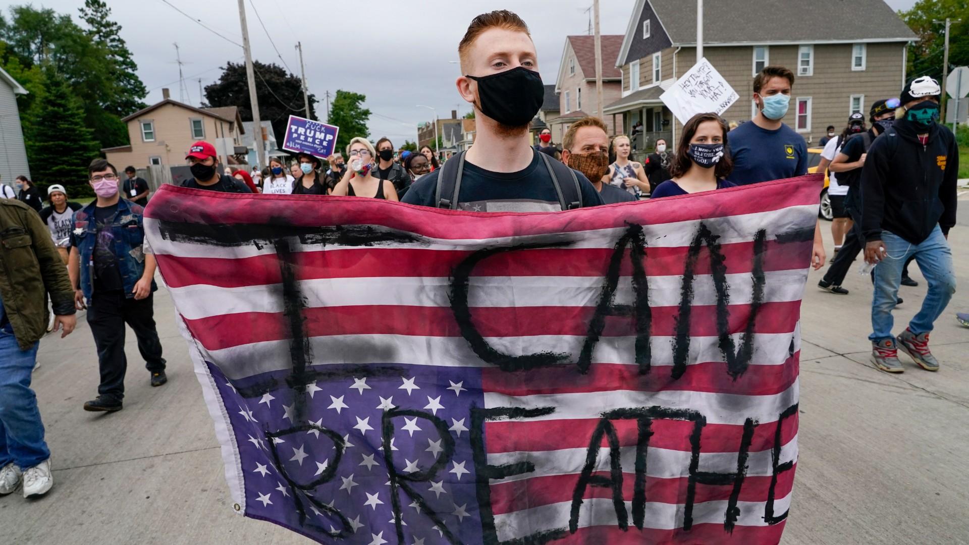 A protester holds a flag during a Black Lives Matter protest Tuesday, Sept. 1, 2020, in Kenosha, Wis. (AP Photo / Morry Gash)