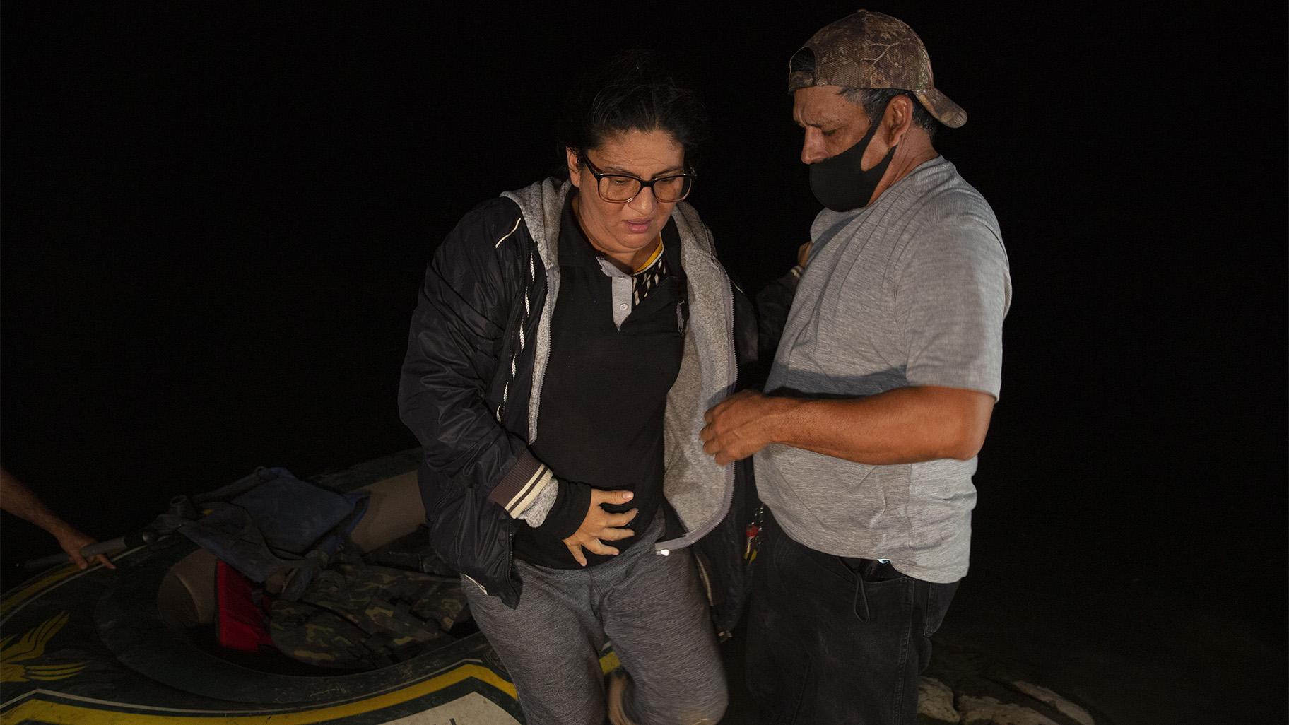 In this March 30, 2021, file photo Mayra Culio from Guatemala is helped off an inflatable raft by a church volunteer after being smuggled across the Rio Grande river in Roma, Texas. (AP Photo / Dario Lopez-Mills)