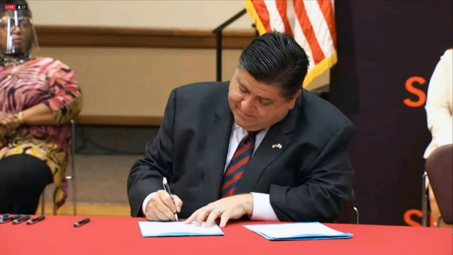 Gov. J.B. Pritzker signs the Feminine Hygiene Products for the Homeless Act on Thursday, Aug. 5, 2021. (WTTW News via Governor’s Office)