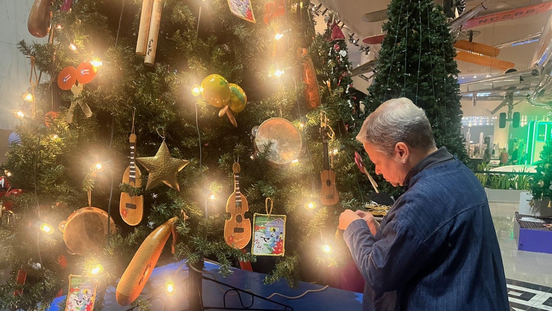 Finishing touches are put on the tree representing Puerto Rico at the Museum of Science and Industry on Nov. 11, 2023. (Angel Idowu / WTTW News)