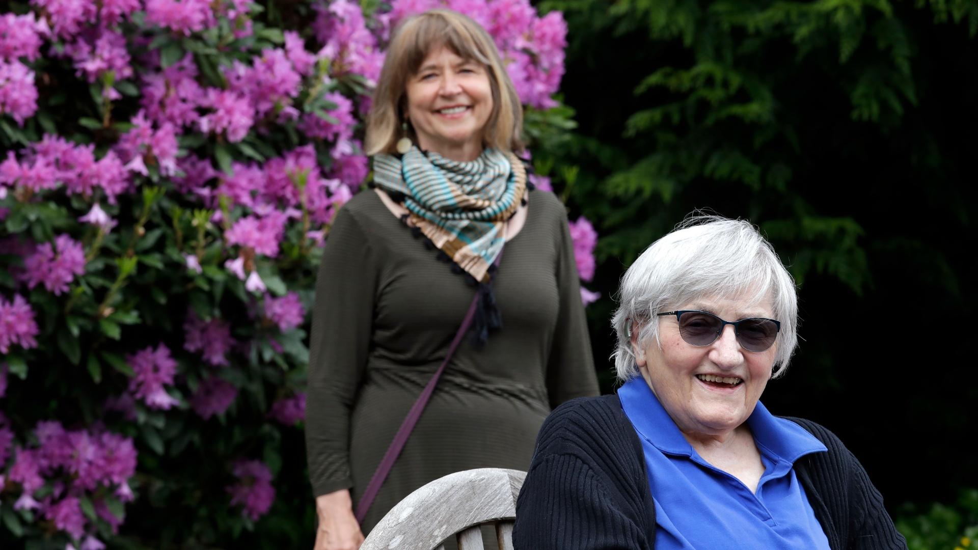 Jessie Cornwell, a resident of the Ida Culver House Ravenna, right, poses for a photo with the Rev. Jane Pauw, in Seattle on May 21, 2020. Cornwell tested positive for the coronavirus but never became ill, and may have been infectious when she shared a ride to Bible study with Pauw, who later got sick with COVID-19. (AP Photo / Elaine Thompson)