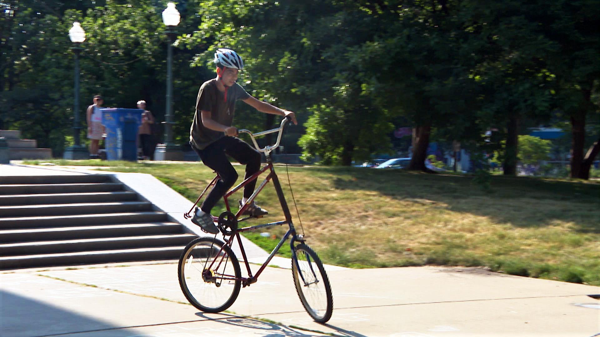 Malcolm Langford, 14, rides a tall bike at a Logan Square Park meetup organized by the custom bike club Rat Patrol on June 11. (WTTW News)