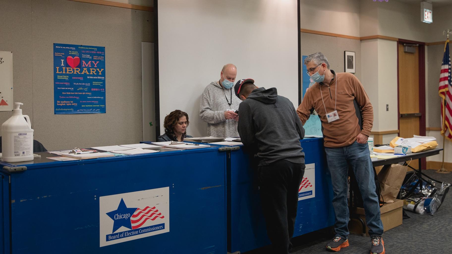 People show documentation as they prepare to vote in the April 4, 2023, Chicago runoff election at the Budlong Woods Library polling location. (Michael Izquierdo / WTTW News)