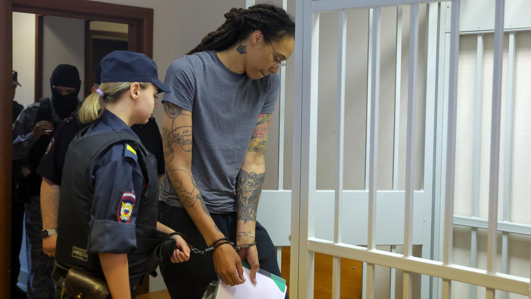 WNBA star and two-time Olympic gold medalist Brittney Griner, right, enters a cage in a courtroom prior to a hearing in Khimki just outside Moscow, Russia, Thursday, Aug. 4, 2022. (Evgenia Novozhenina / Pool Photo via AP)
