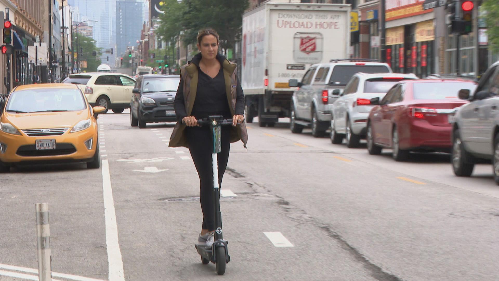 A woman rides a scooter in Chicago during the city’s first pilot program in 2019. (WTTW News)