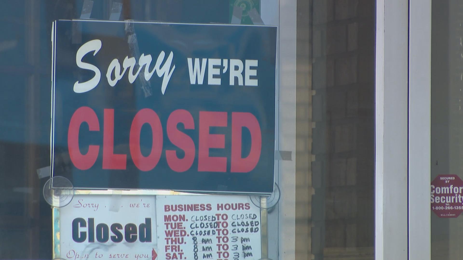 A small business hangs a “closed” sign on its door during the pandemic in April 2020. (WTTW News)