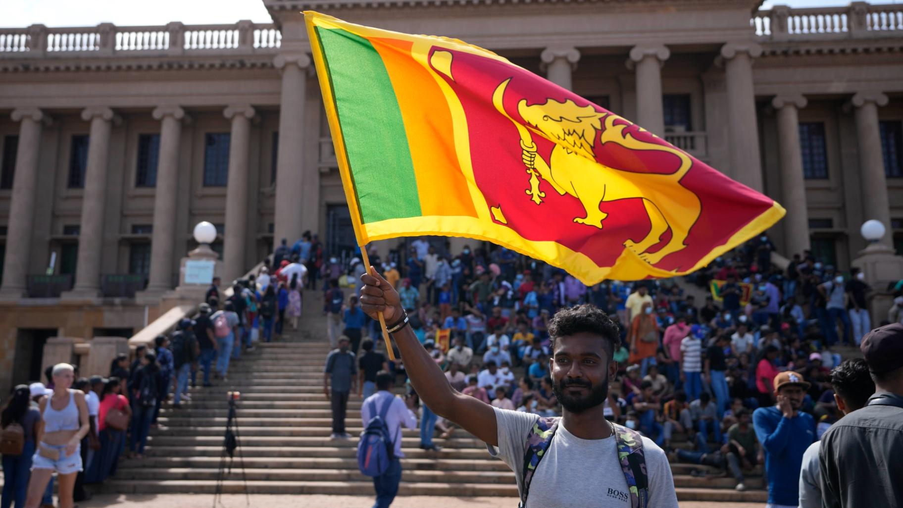 A protester waves a national flag outside president Gotabaya Rajapaksa’s office in Colombo, Sri Lanka, Wednesday, July 13, 2022. (AP Photo / Eranga Jayawardena)