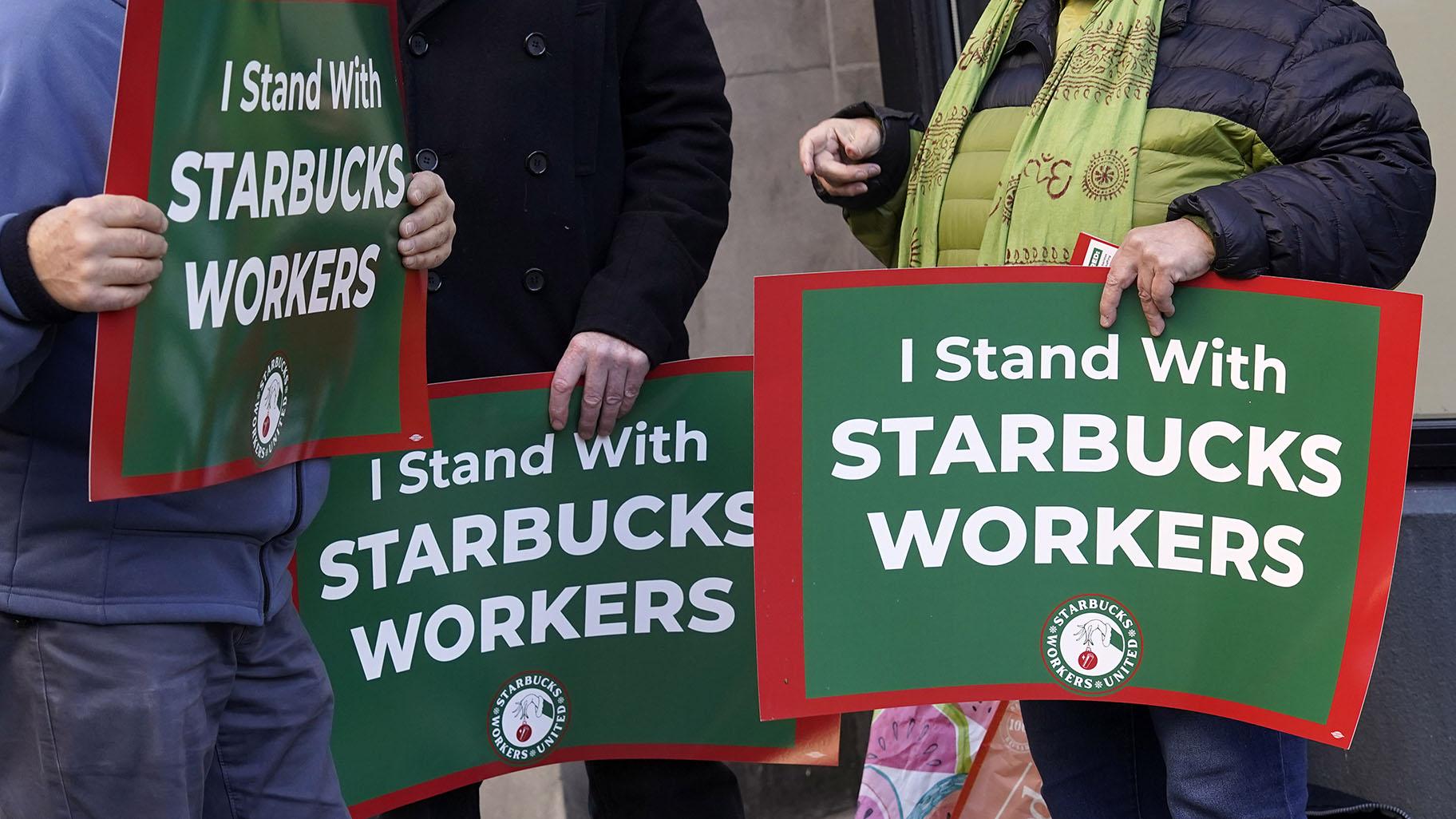 Arlene Geiger, left, holds a sign supporting Starbucks workers outside a Starbucks on New York's Upper West Side, Thursday, Nov. 16, 2023. Thousands of workers at more than 200 U.S. Starbucks stores plan to walk off the job Thursday in what organizers say is the largest strike yet in the two-year-old effort to unionize the company's stores. (AP Photo/Richard Drew)