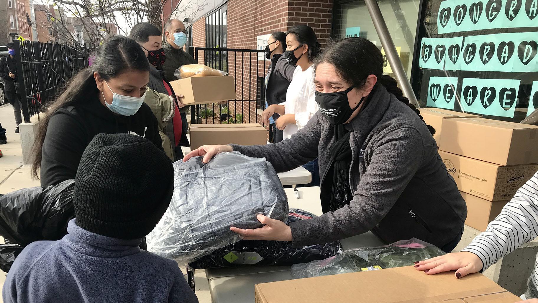 Families pick up Thanksgiving meal boxes and coats for their children at West Town nonprofit Northwestern Settlement on Saturday, Nov. 21, 2020. (Ariel Parrella-Aureli / WTTW News)