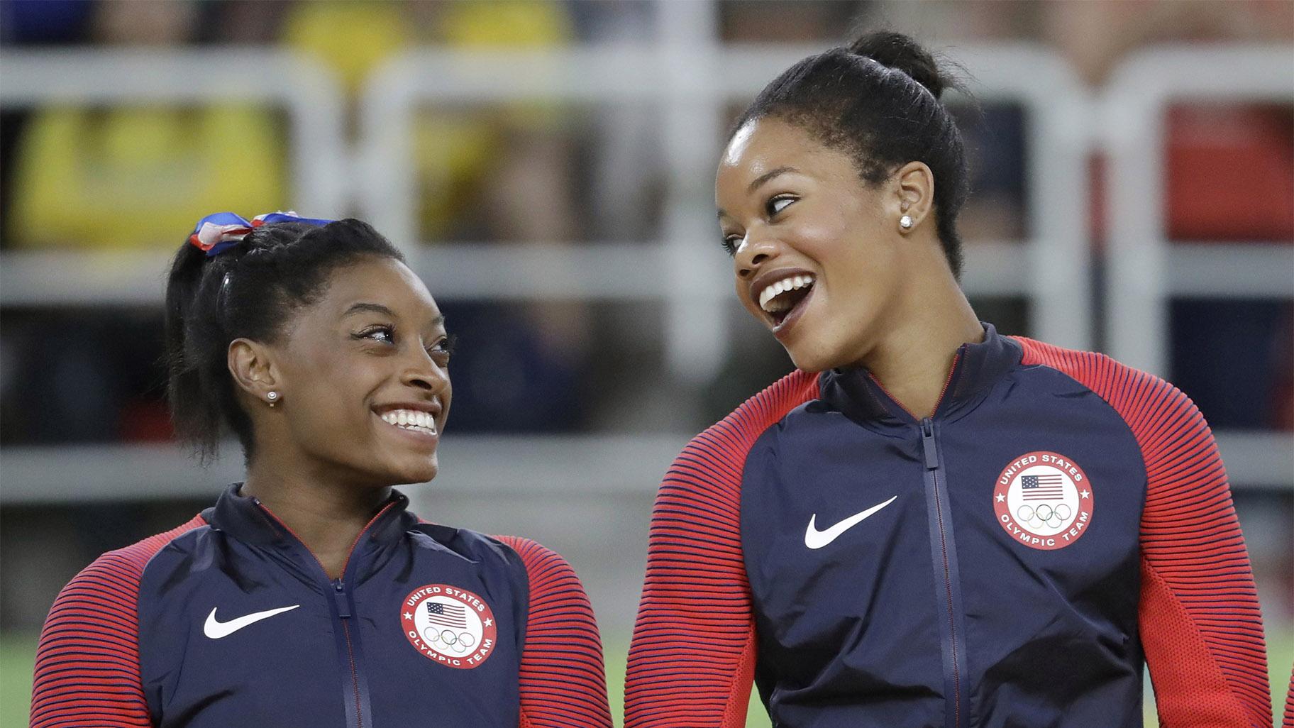 In this Aug. 9, 2016, file photo, U.S. gymnasts and gold medallists, Simone Biles, left and Gabrielle Douglas celebrate on the podium during the medal ceremony for the artistic gymnastics women's team at the 2016 Summer Olympics in Rio de Janeiro, Brazil. (AP Photo / Julio Cortez, File)