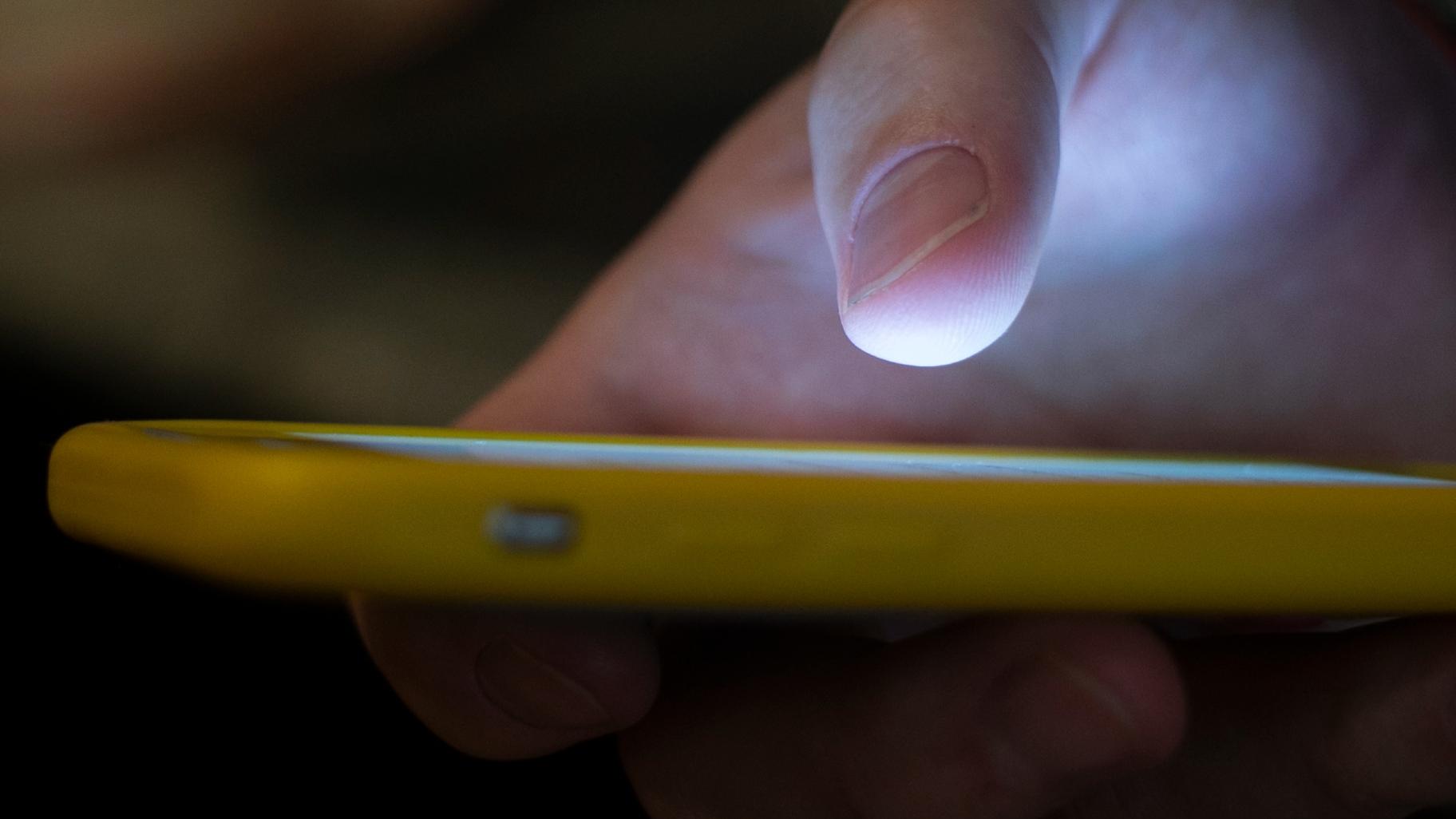 FILE - A man uses a cell phone in New Orleans on Aug. 11, 2019. (AP Photo / Jenny Kane, File)