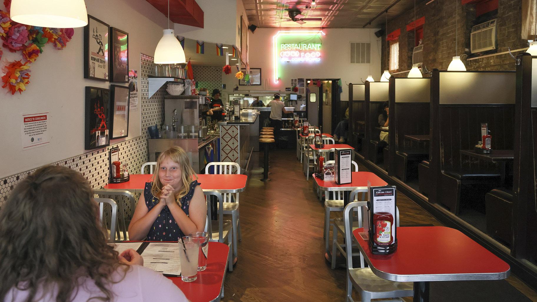 Flower Nichols, an 11-year-old transgender girl, eats with her mother at a restaurant during a visit to Chicago on June 13, 2023. (AP Photo / Teresa Crawford)