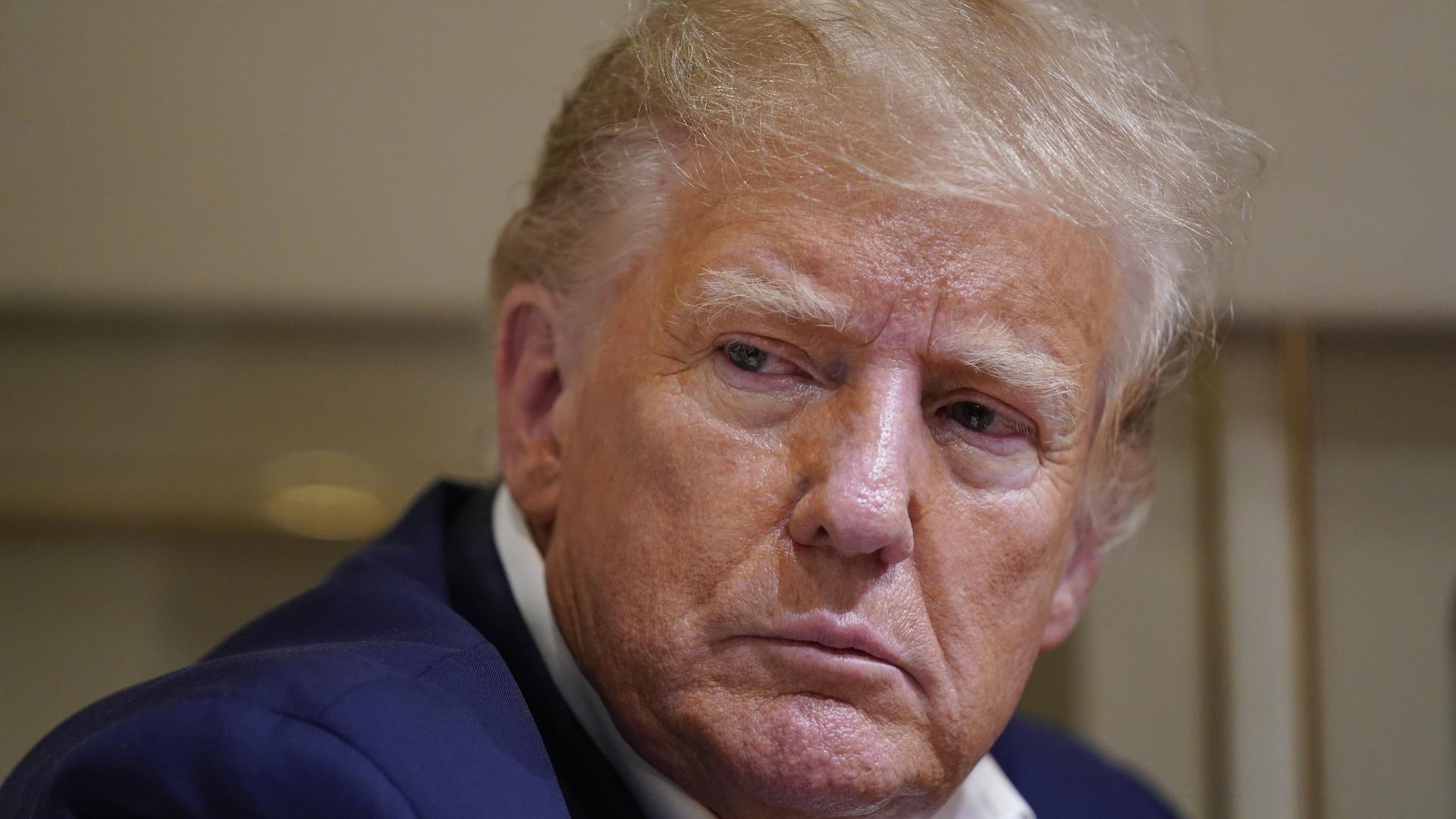 Former President Donald Trump listens as he speaks with reporters while in flight on his plane after a campaign rally at Waco Regional Airport, in Waco, Texas, March 25, 2023, while en route to West Palm Beach, Fla. (AP Photo/Evan Vucci, File)