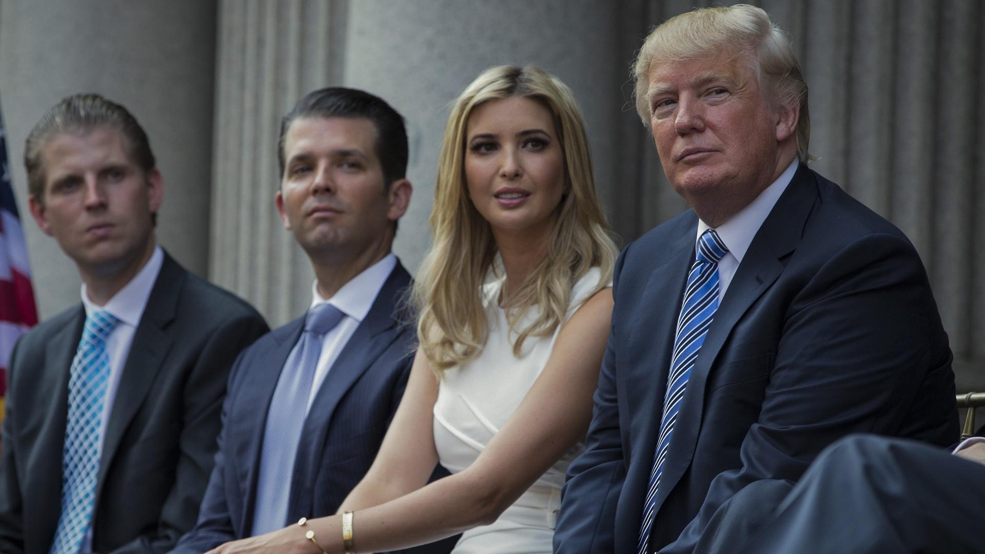 Donald Trump, right, sits with his children, from left, Eric Trump, Donald Trump Jr., and Ivanka Trump during a groundbreaking ceremony for the Trump International Hotel on July 23, 2014, in Washington. (AP Photo/Evan Vucci, File)