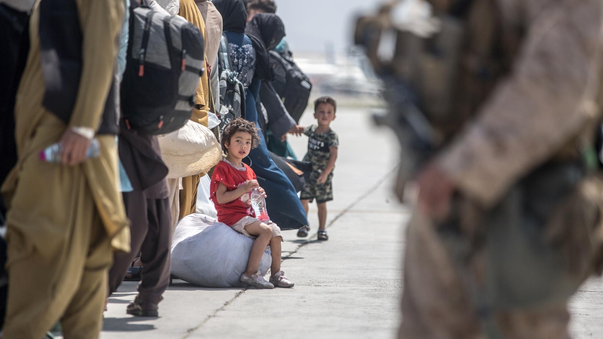 In this Aug. 22, 2021, image provided by the U.S. Marine Corps, a child waits with her family to board a U.S. Air Force Boeing C-17 Globemaster III during an evacuation at Hamid Karzai International Airport in Kabul, Afghanistan. (Sgt. Samuel Ruiz/U.S. Marine Corps via AP)