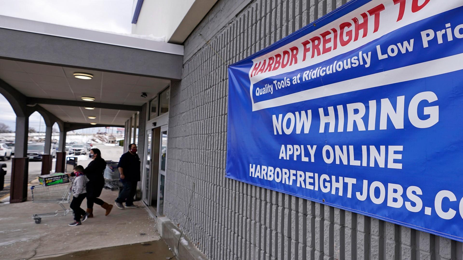 In this Dec. 10, 2020, file photo, a “Now Hiring” sign hangs on the front wall of a Harbor Freight Tools store in Manchester, N.H. (AP Photo / Charles Krupa, File)
