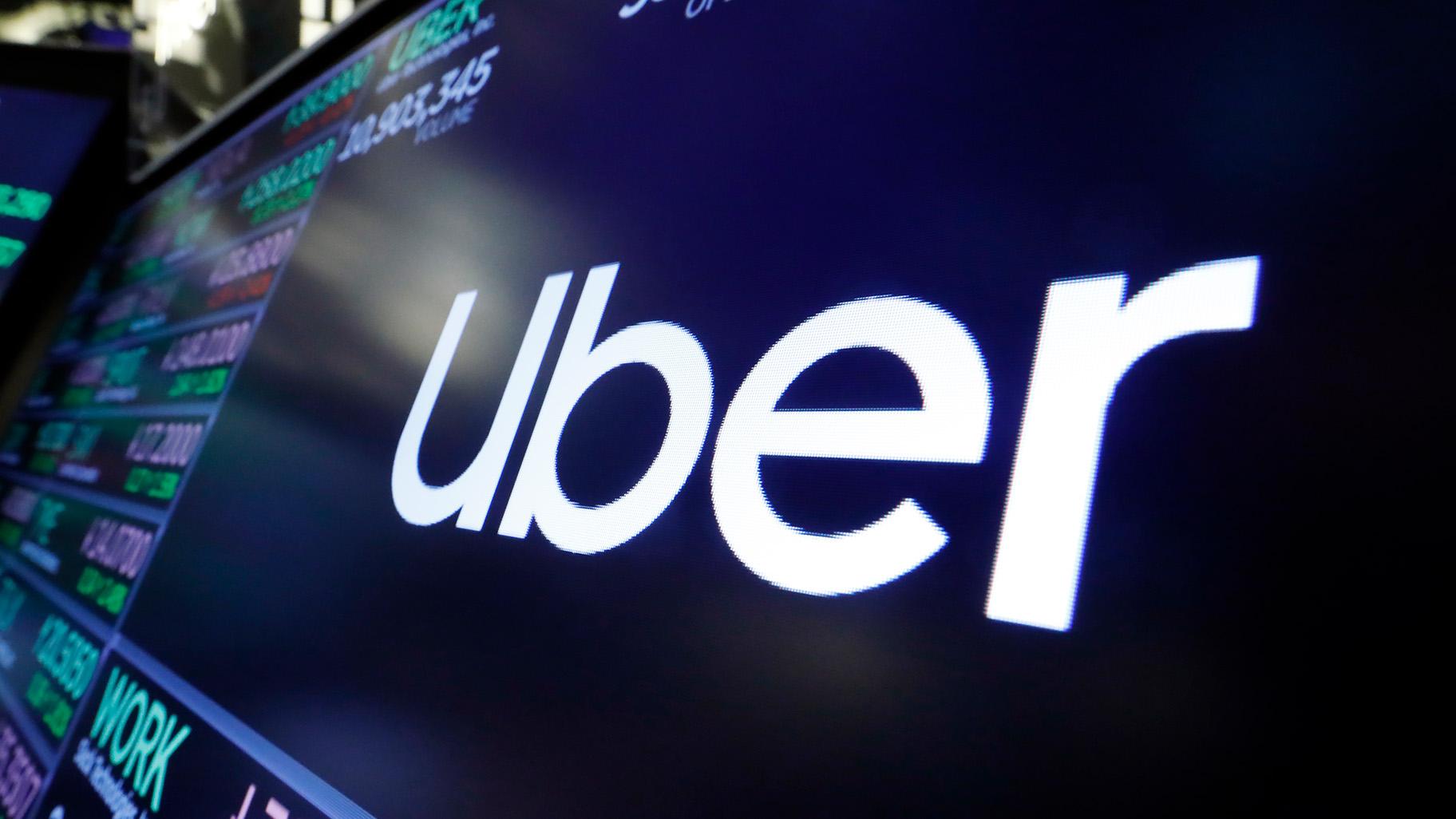 FILE - The Uber logo appears above a trading post on the floor of the New York Stock Exchange, Aug. 16, 2019. (Richard Drew / AP Photo, File)