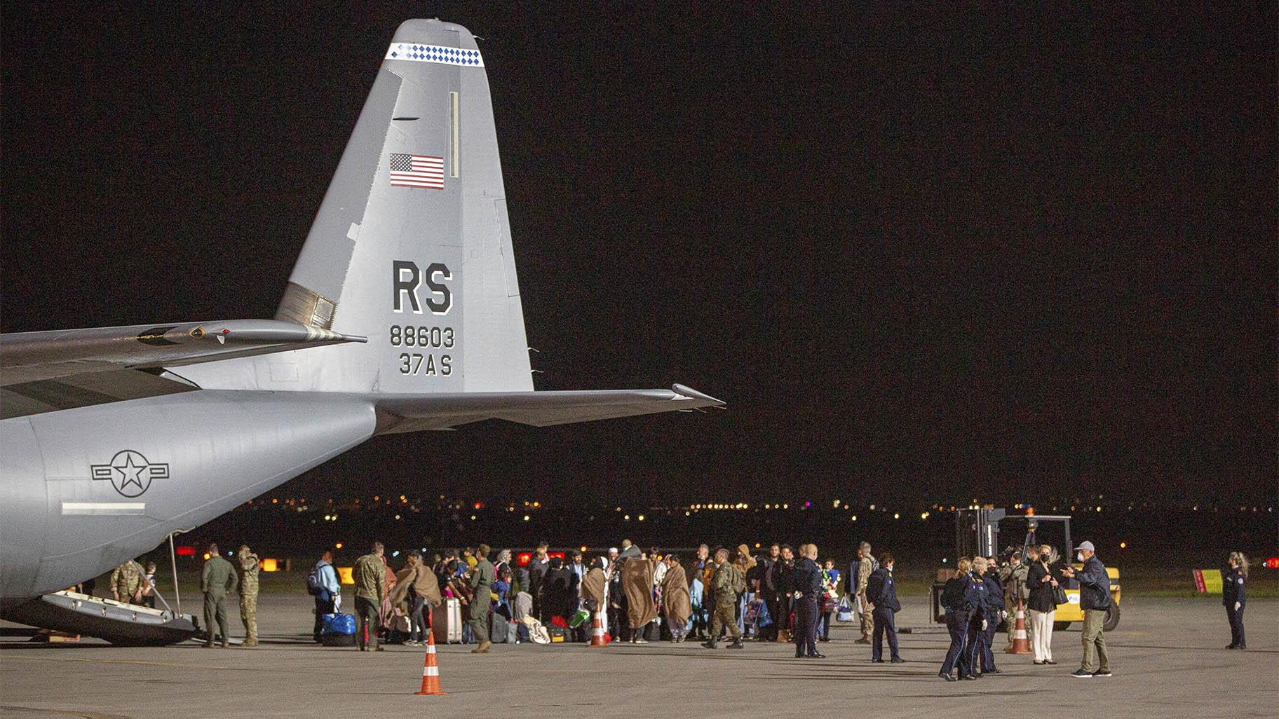 FILE - In this Aug. 29, 2021, file photo families evacuated from Kabul, Afghanistan, walk past a U.S Air Force plane that they arrived on at Kosovo's capital Pristina International Airport. (AP Photo / Visar Kryeziu, File)