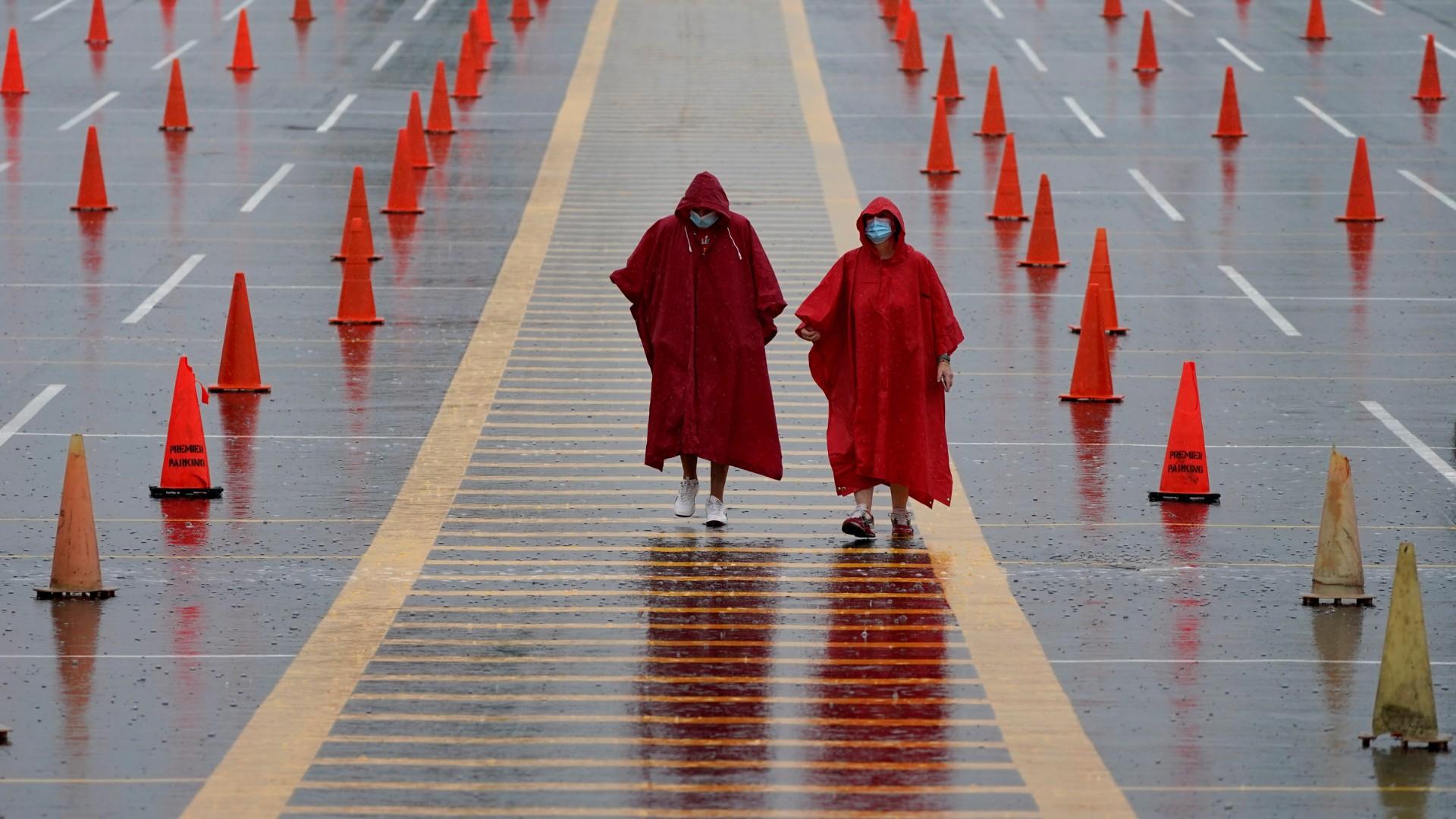 In this Aug. 29, 2020, file photo, fans walk through a parking lot at Arrowhead Stadium marked with traffic cones to keep fans from parking too close together during NFL football training camp for the Kansas City Chiefs in Kansas City, Mo. (AP Photo / Charlie Riedel, File)