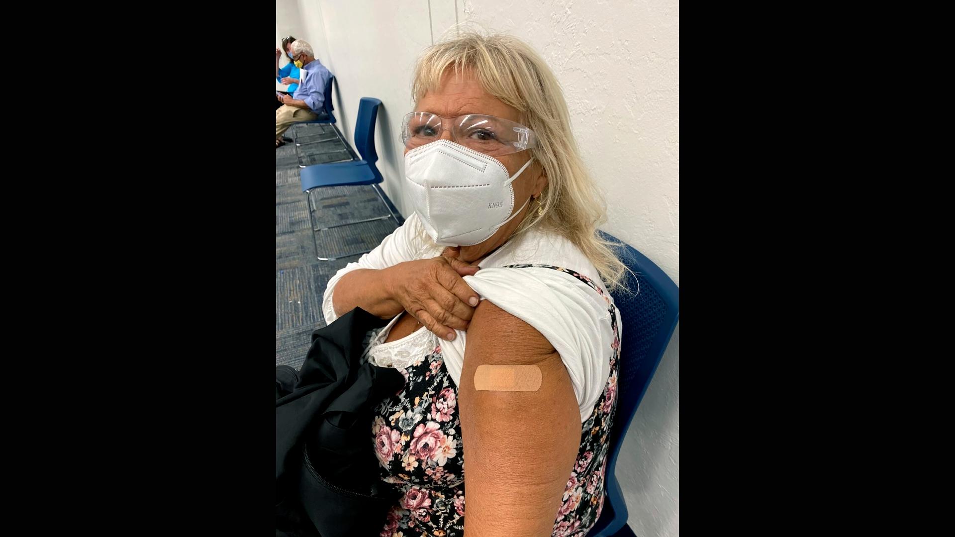 In this photo provided by Terry Beth Hadler , the 69-year-old, poses after receiving a dose of a COVID-19 vaccine on Tuesday, Dec. 29, 2020, at a Bonita Springs, Fla. Library. (Courtesy of Terry Beth Hadler via AP)
