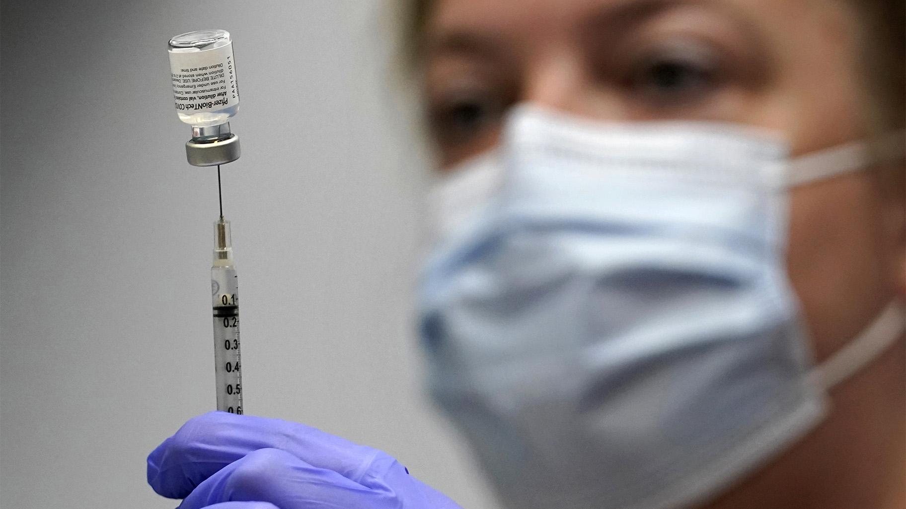 In this March 2, 2021, file photo, Hollie Maloney, a pharmacy technician, loads a syringe with Pfizer's COVID-19 vaccine at the Portland Expo in Portland, Maine. (AP Photo / Robert F. Bukaty, File)