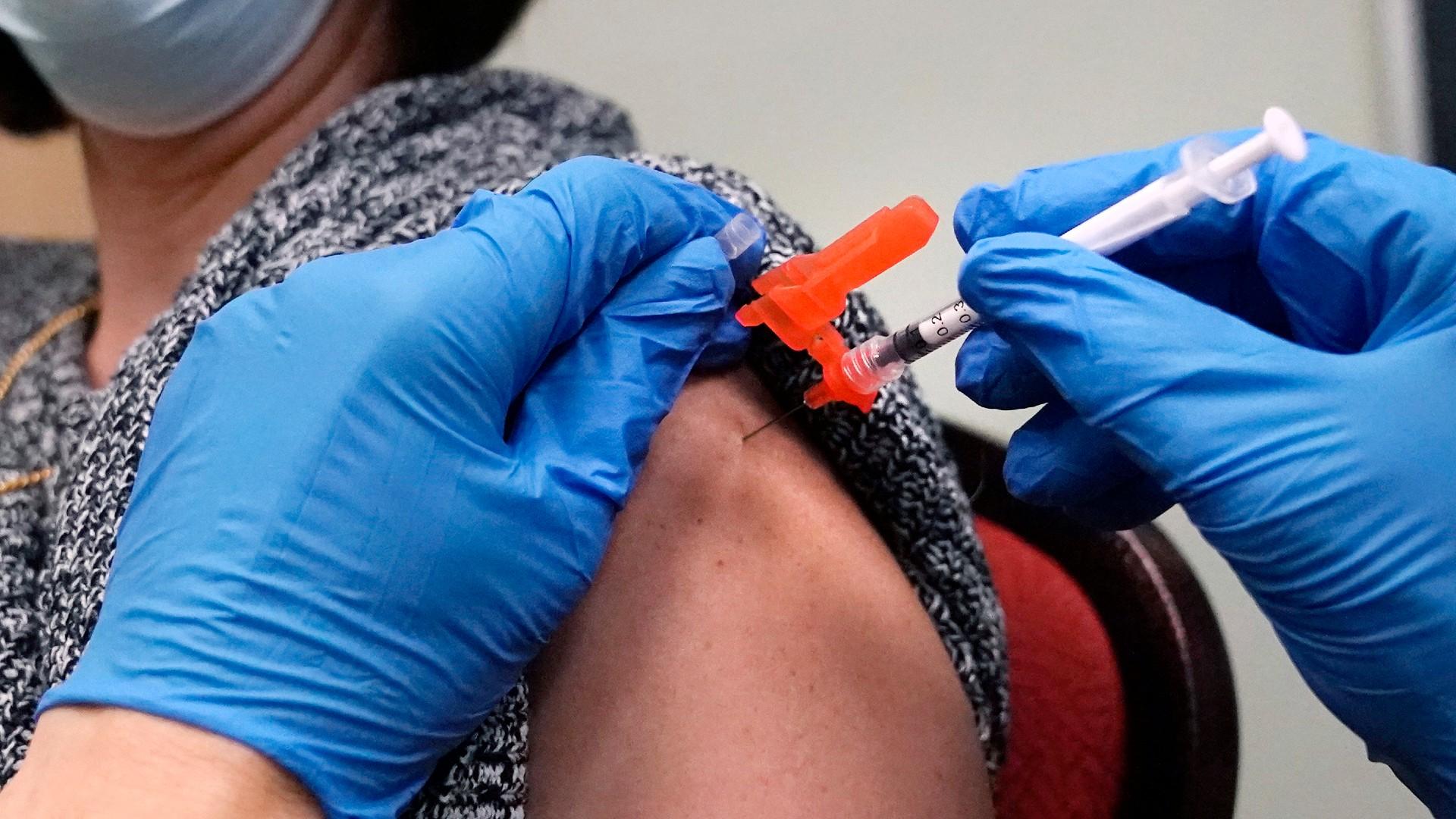 A woman receives a COVID-19 vaccine injection by a pharmacist at a clinic in Lawrence, Mass., on Wednesday, Dec. 29, 2021. (AP Photo / Charles Krupa, File)