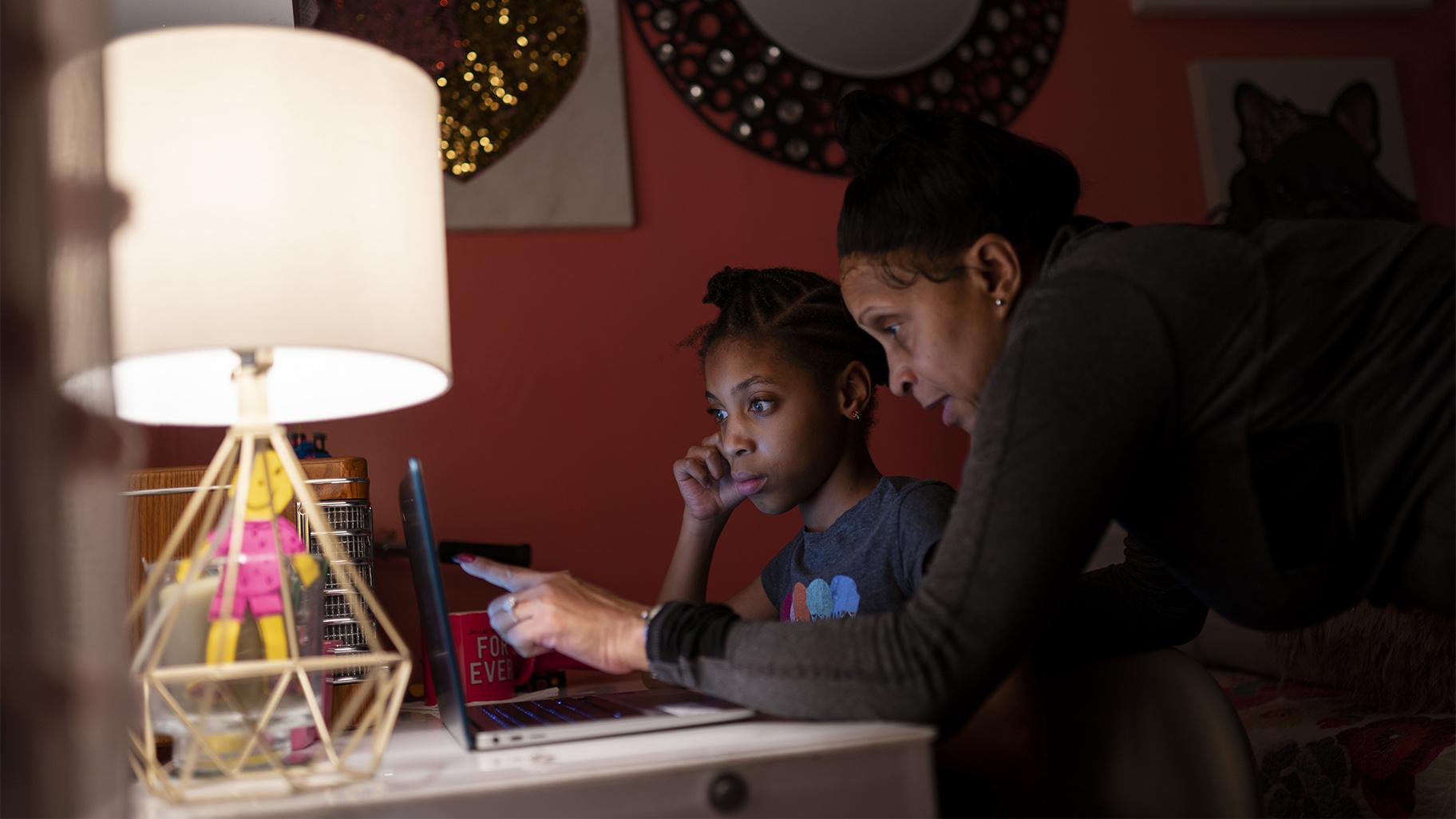 Abigail Schneider, 8, center, completes a level of her learning game with her mother April in her bedroom, Wednesday, Dec. 8, 2021, in the Brooklyn borough of New York. (AP Photo / John Minchillo) 