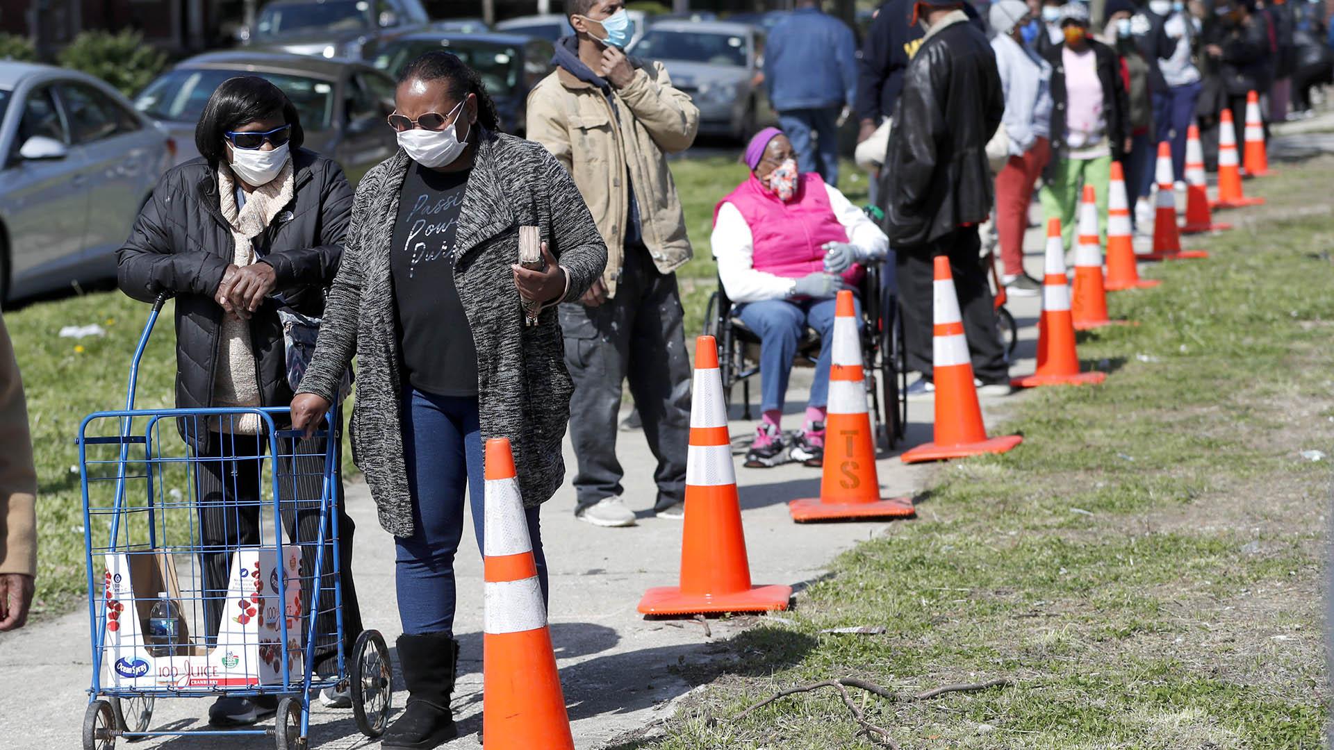 In this Tuesday, May 12, 2020, photo, residents from all walks of life line up for a food giveaway sponsored by the Greater Chicago Food Depository in the Auburn Gresham neighborhood of Chicago. (AP Photo / Charles Rex Arbogast)